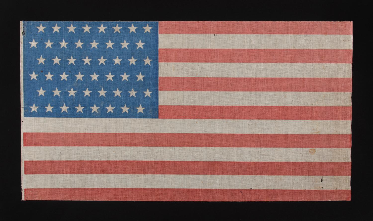 48 STARS IN STAGGERED ROWS ON A PARADE FLAG WITH A BRILLIANT, CORNFLOWER BLUE CANTON, 1896-1918

48 star American national parade flag, printed on coarse cotton, with an attractive, cornflower blue canton and scarlet red stripes.

On June 24th,