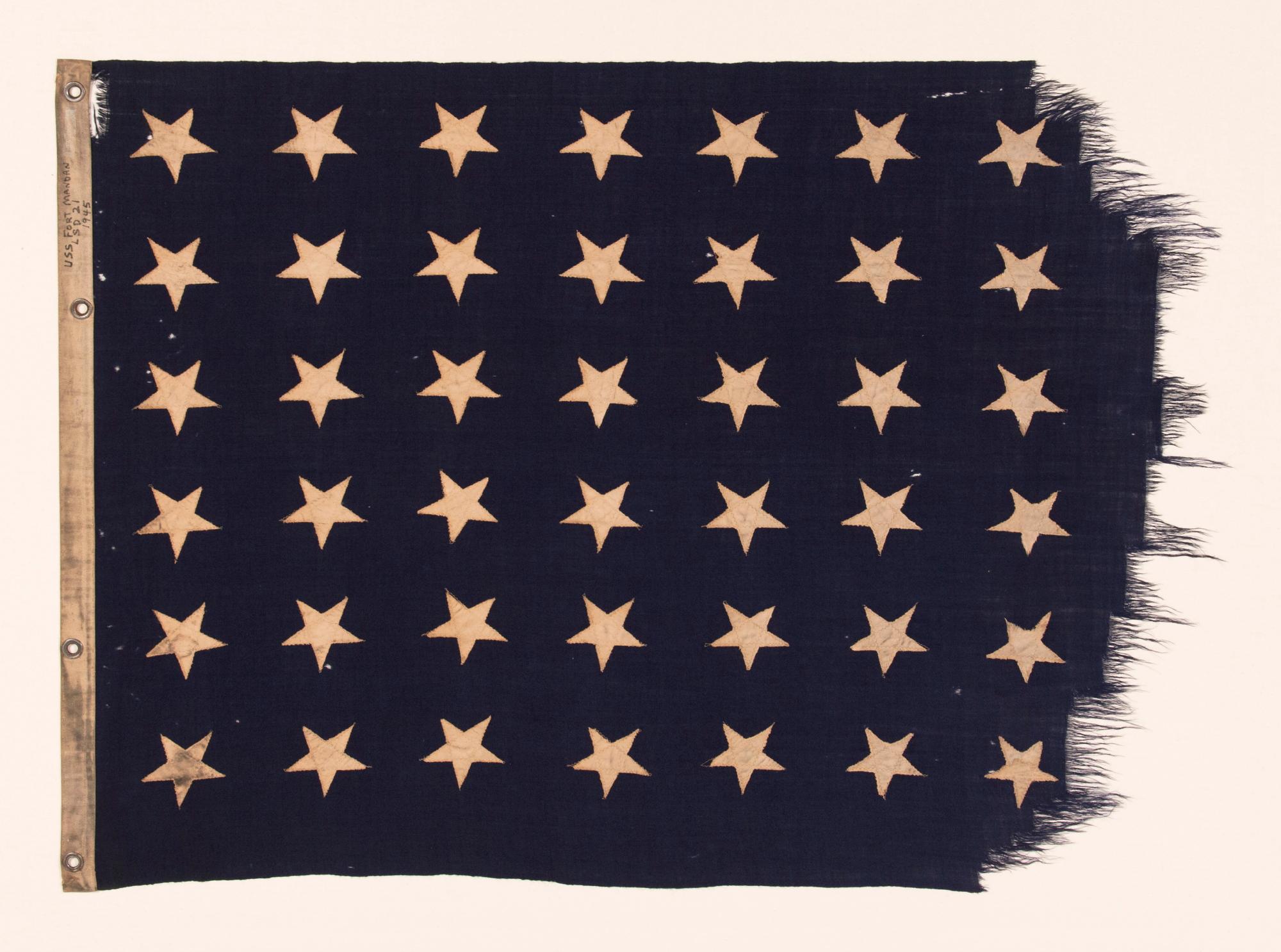 48 STAR U.S. NAVY JACK, MARKED AS HAVING BEEN FLOWN ON THE U.S.S. FT. MANDAN, LAUNCHED NEAR THE END OF WWII, IN 1945, WITH SERVICE DURING BOTH THE KOREAN AND VIETNAM WAR ERAS, IN THE ARCTIC, AT THE NORTH POLE, AND AT GUANTANAMO BAY DURING THE CUBAN