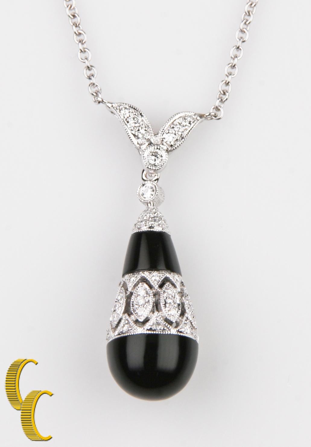 the pendant features a layered onyx & diamond dangle, completed by a diamond set floral motif bail
the pendant is supported by a sixteen inch 18k white gold designer style chain, terminating in a lobster claw clasp
bright and patterned finish with