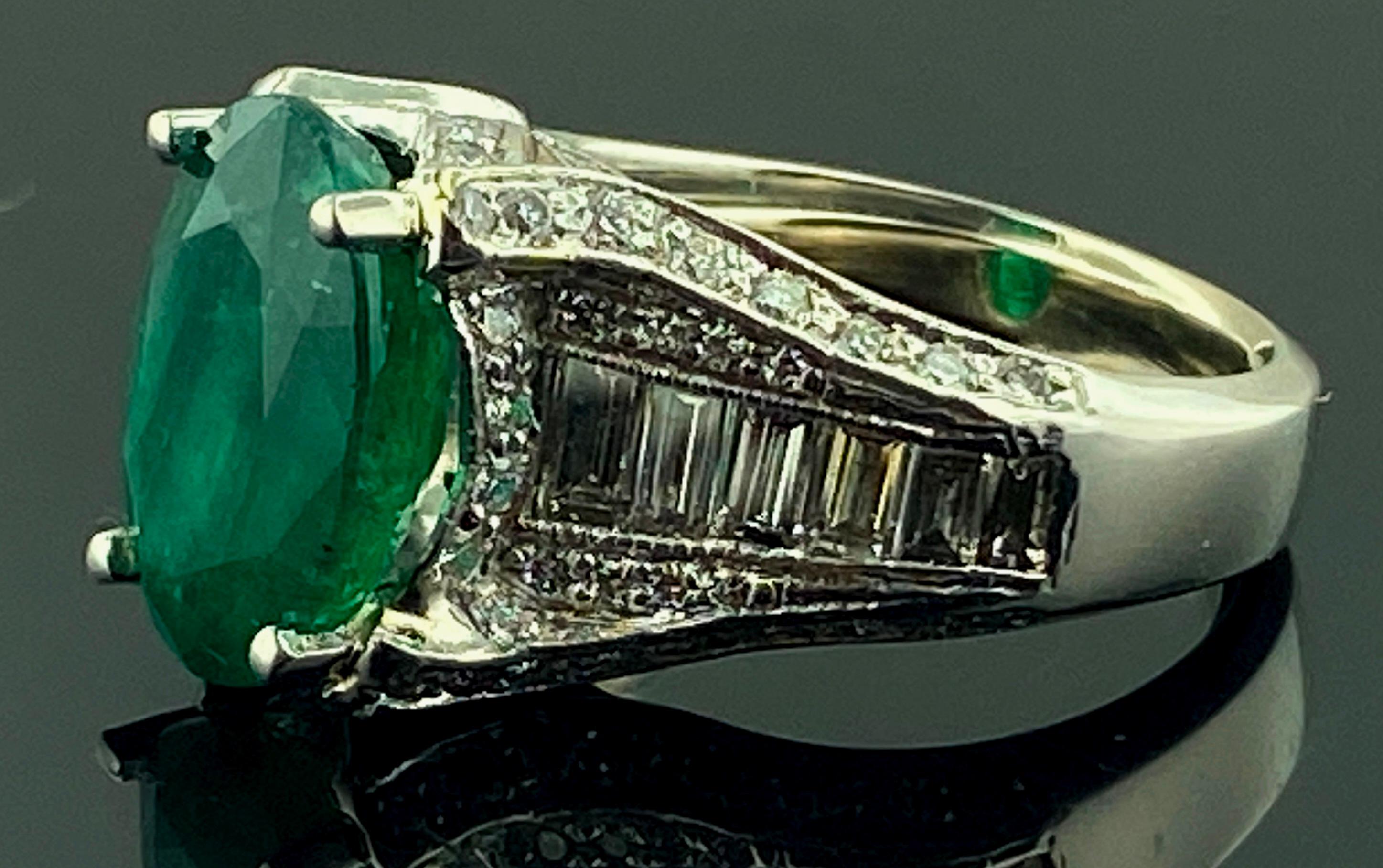 Set in Platinum, with a weight of 16.75 grams, is a 4.80 carat oval cut Emerald flanked with 12 baguette cut diamonds plus 84 round brilliant cut diamonds, with a total diamond weight of 1.85 carats.  Color is G-H, Clarity is VVS.  Ring size is 5.5.