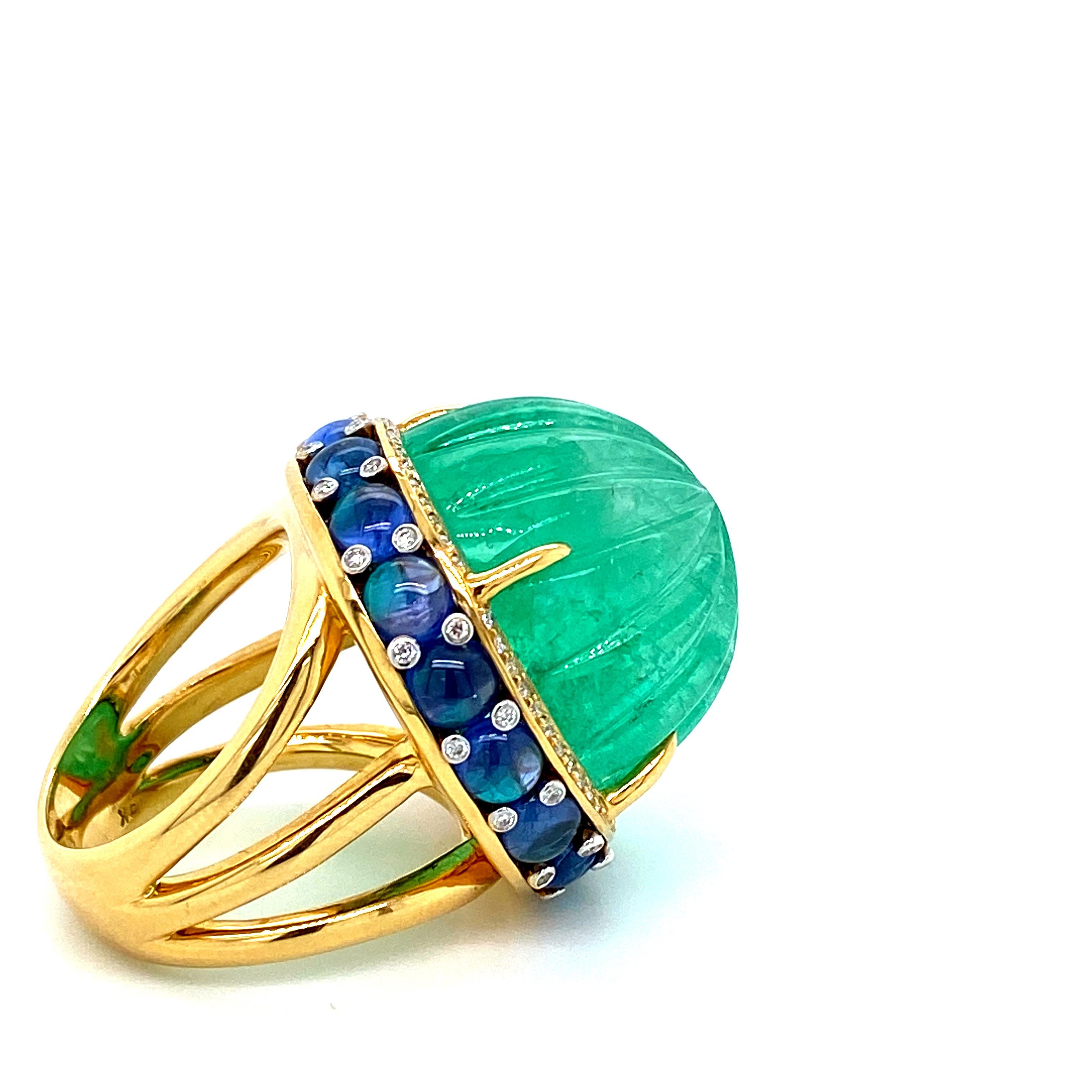48.07 Carat GRS Certified Colombian Carved Emerald And Diamond Cocktail Ring:

A magnificent and rare ring, it features a massive 48.07 carat GRS Certified carved Colombian Emerald cabochon, accented by Blue Sapphire Cabochons weighing 8.94 carat