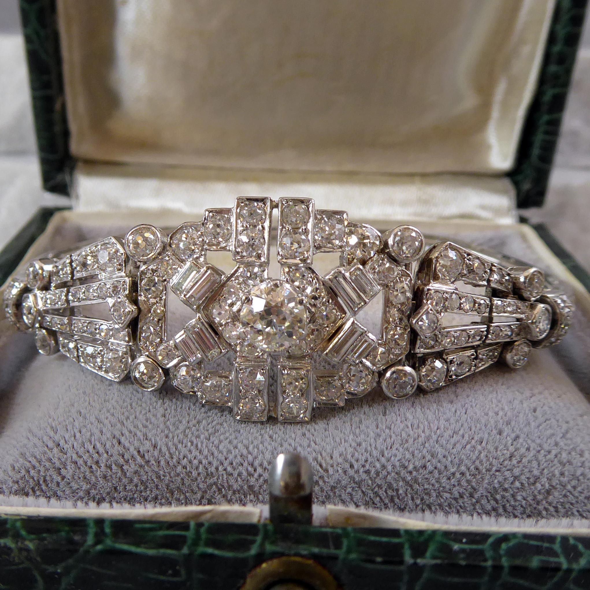 An Art Deco diamond bracelet comprised of panel links which  encompass old European cut, single cut, old Swiss Cut and trap cut diamonds.  The central panel tapering down to a single line of old round brilliant cut diamonds, grain set within square