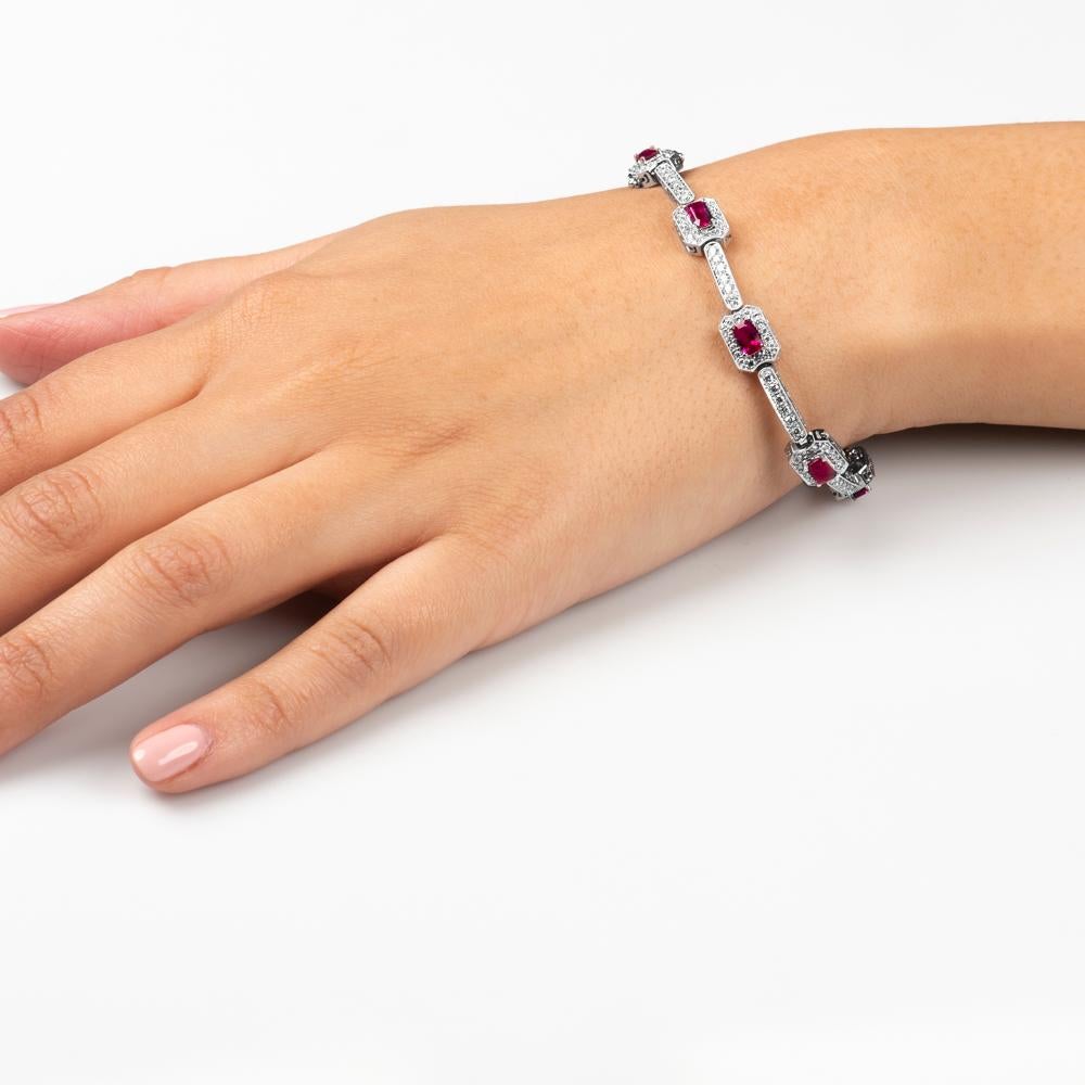Beautiful 4.82 carat total emerald cut ruby bracelet with 2.21 carat total weight of round brilliant diamonds surrounding the rubies. Designed in 18K white gold with milgrain and filigree detail all around the bracelet. 
Diamond quality: G-H color,