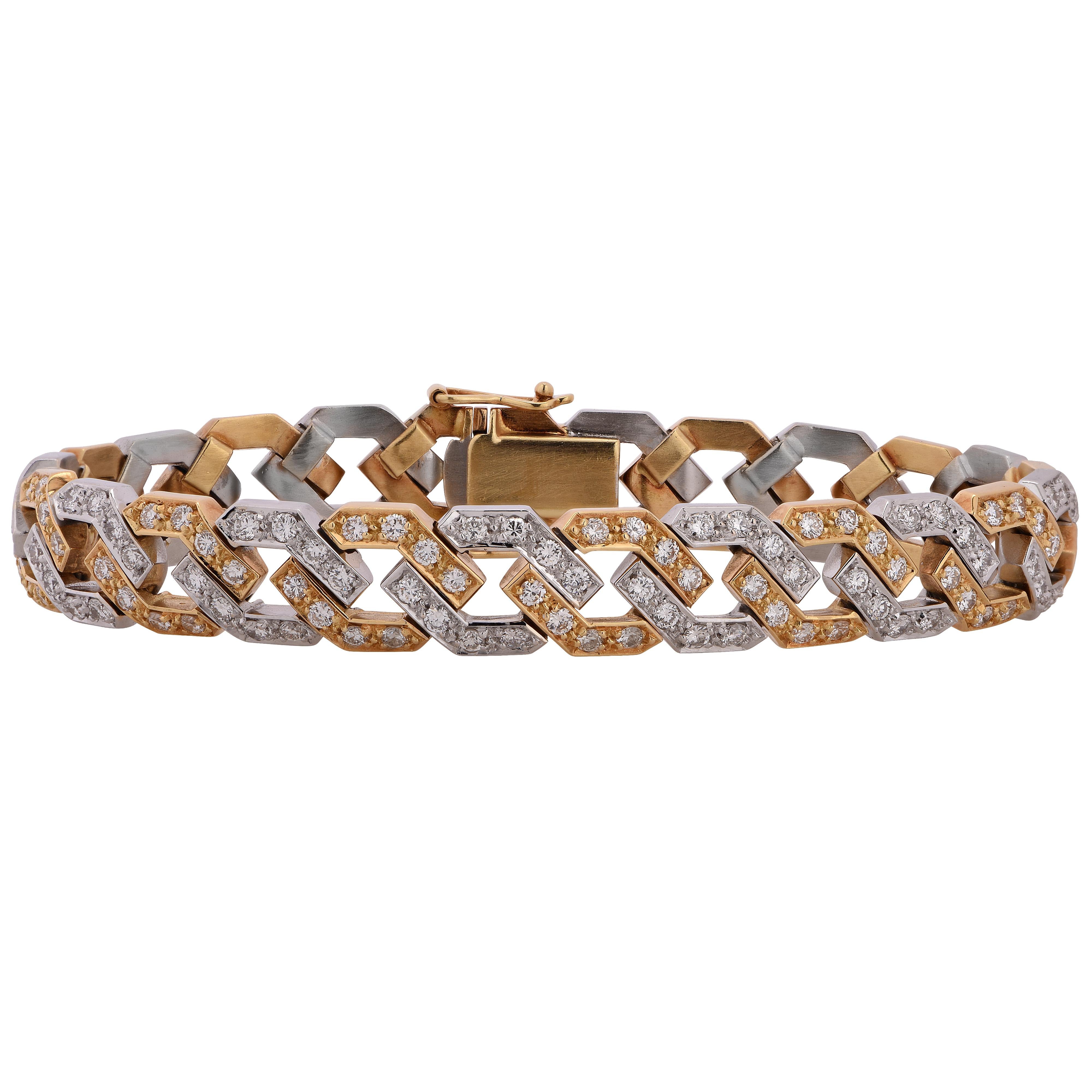 Striking bracelet crafted in 18k white and yellow gold featuring 192 round brilliant cut diamonds weighing 4.83 carats total, G color VS clarity. Diamond encrusted white gold and yellow gold links alternate and interlock to create a piece that is