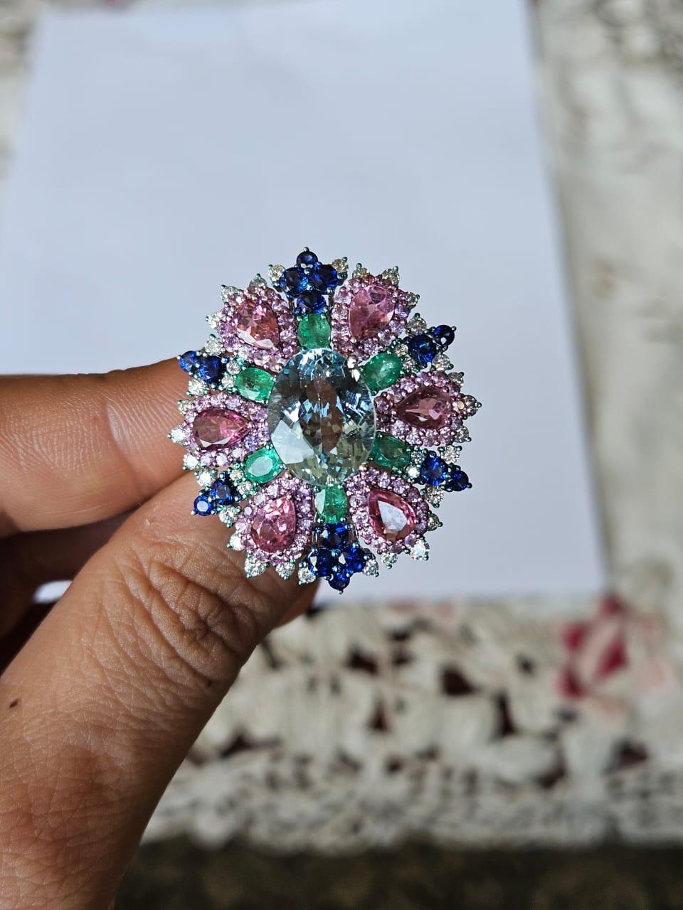 A very gorgeous and beautiful, one of a kind, modern style, Aquamarine, Blue Sapphires, Pink Sapphires & Emeralds Cocktail Ring set in 18K White Gold & natural Diamonds. The weight of the Aquamarine is 4.83 carats. The weight of the Blue and Pink