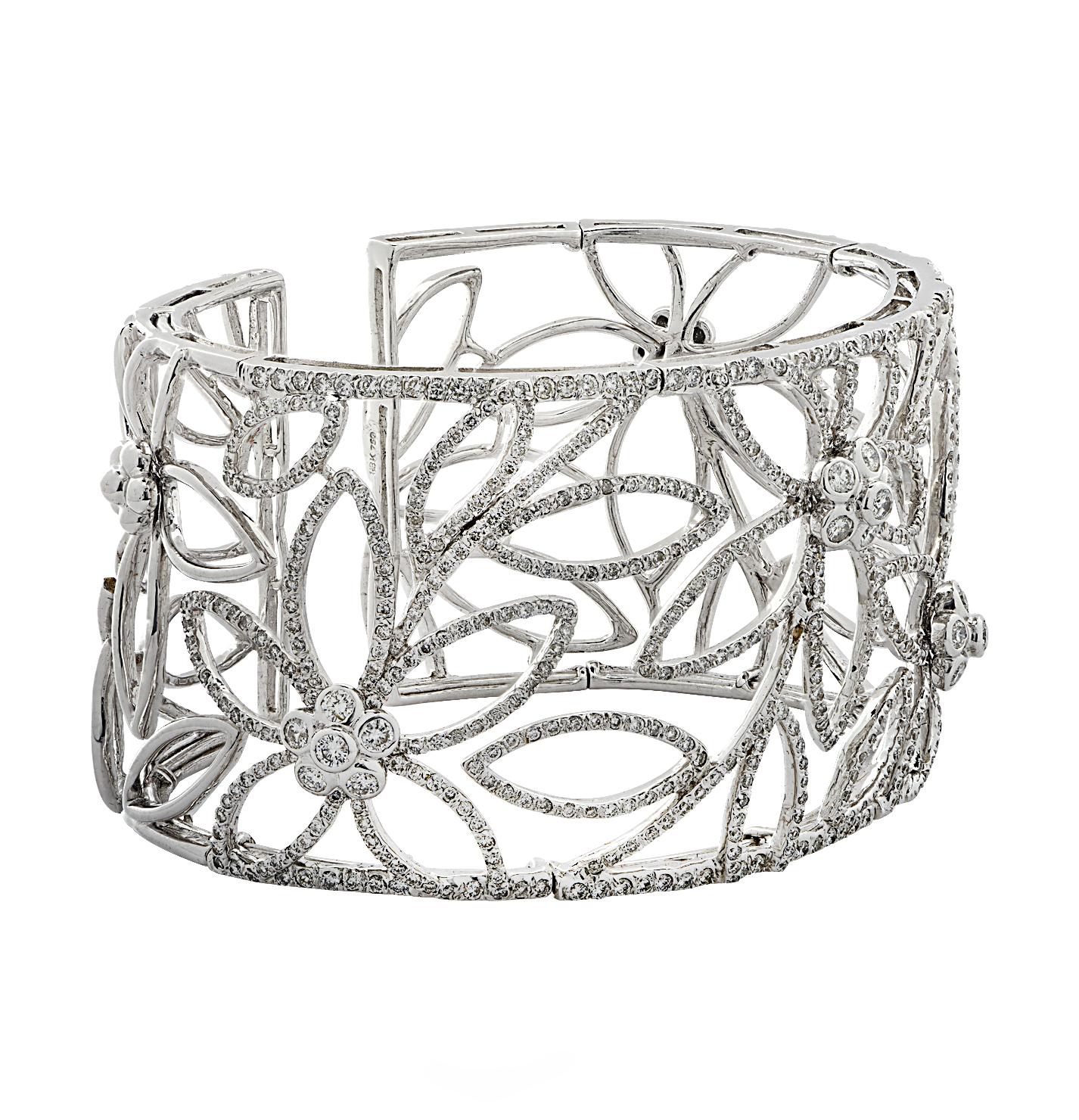 Enchanting cuff bangle bracelet crafted in 18 karat white gold, featuring round brilliant cut diamonds weighing approximately 4.84 carats total, H-I color, SI-I1 clarity. Stunning white gold diamond encrusted open work flowers wrap around the wrist,