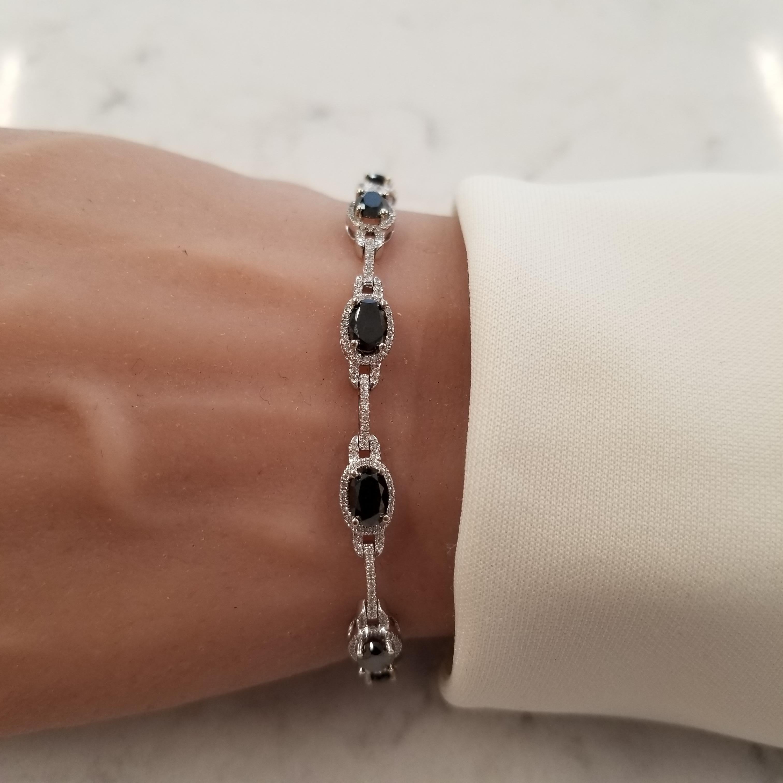 The color concept on this stunning bracelet resembles the keys on a classic piano. It boasts 10 oval cut, prong set, black diamonds totaling 4.84 carats. These rich black diamonds are complemented by sparkling round brilliant cut diamonds, that are