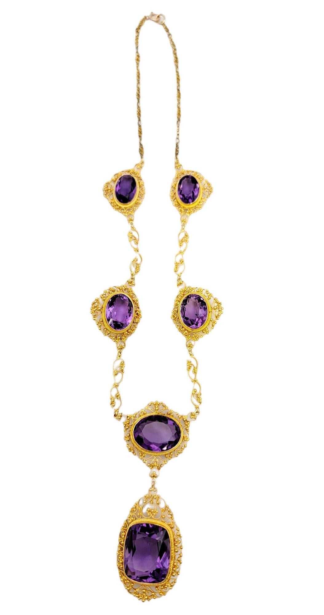 Absolutely stunning amethyst station necklace with an intricately detailed 21 karat yellow gold filigree design. This gorgeous necklace makes a big statement. The beautifully saturated bright purple amethyst stones really pop against the luxurious