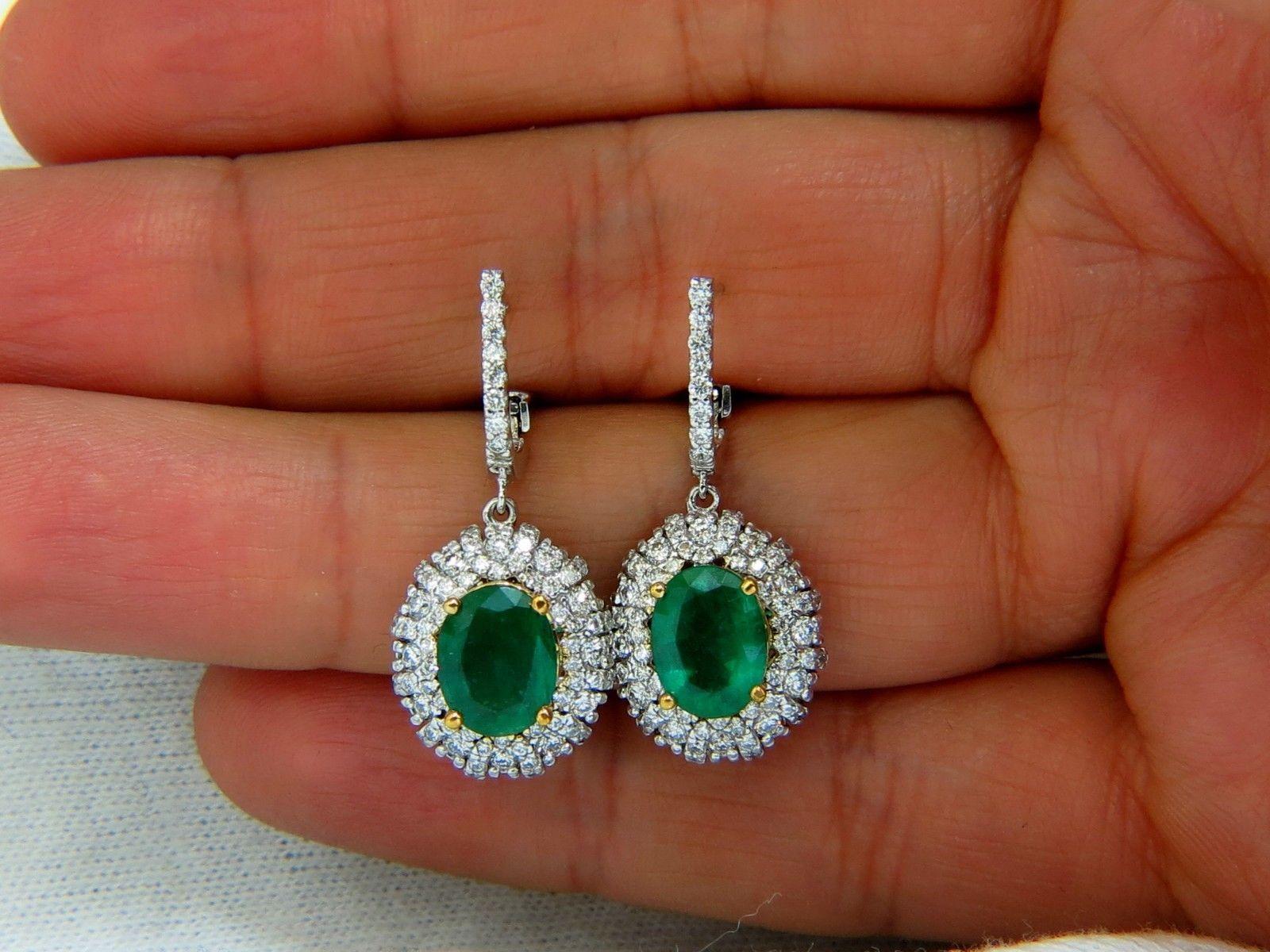 Modern Dangles.
3.44ct. Natural (2) Emeralds
Emeralds: Ovals brilliant cuts.
Transparent & Even Green tone.
Ranging: 9 X 7mm
1.40cts of round diamonds: 
G-color, Vs-2 clarity.
14kt. white gold
7.2 grams.
Earrings are .54 inch wide lower