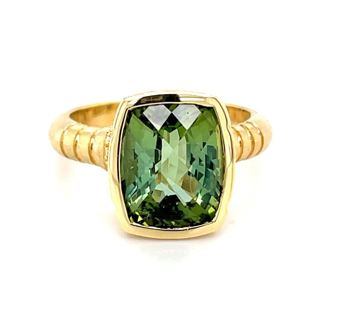This one-of-a-kind ring features a brilliant and bright green tourmaline weighing 4.85 carats, with a unique 