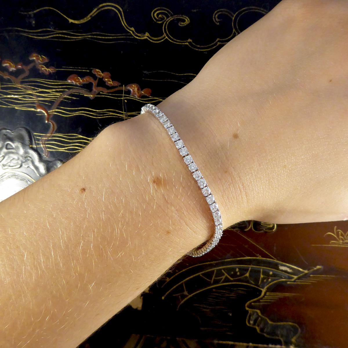 This gorgeous Tennis bracelet has been crafted in 18ct White Gold. Featuring a collection of 59 evenly matched Modern Brilliant Cut Diamonds and a diamond set v snap box clasp with fold over safety clasp on each side for peace of mind, giving it a