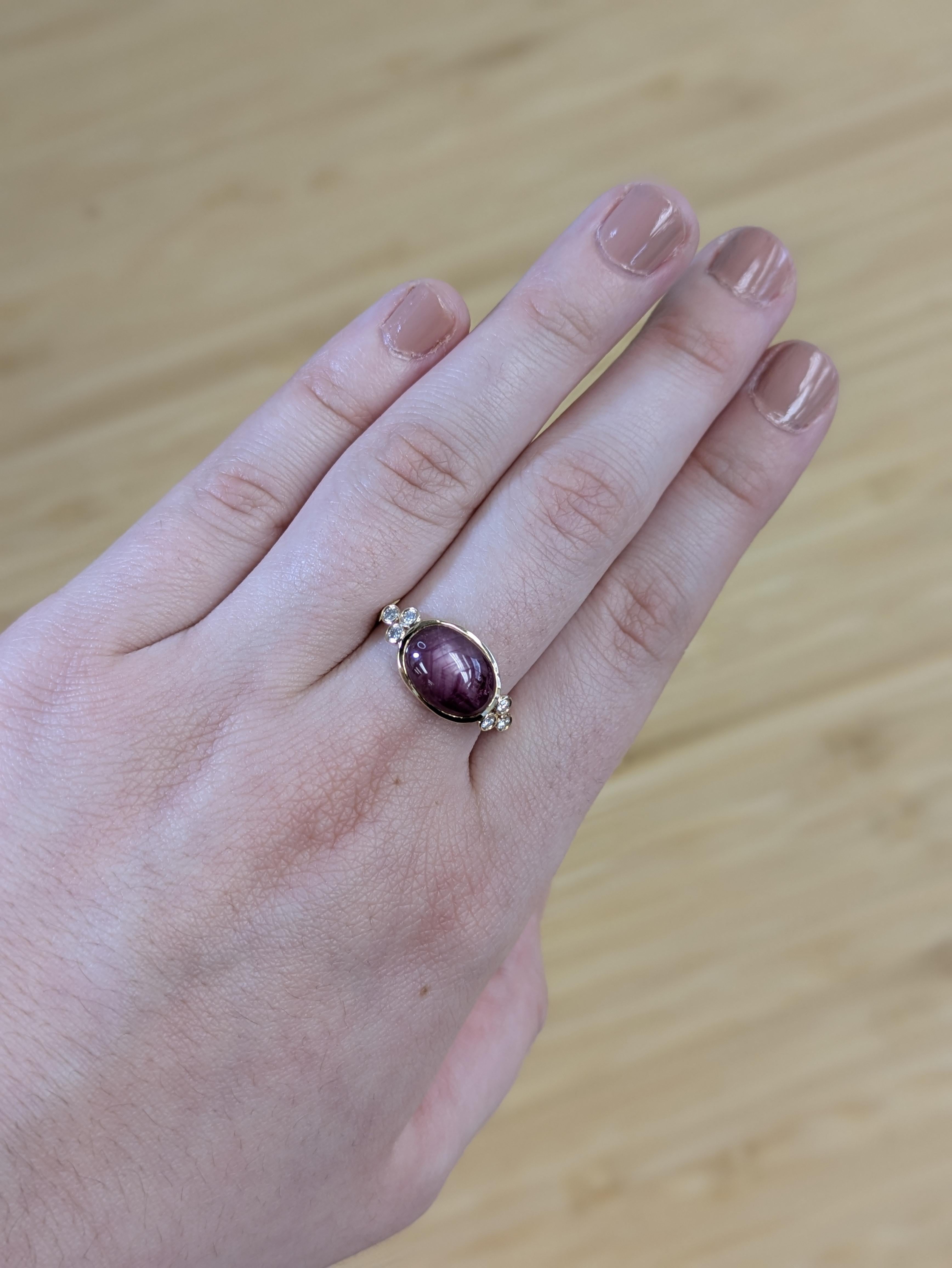 Bold meets beautiful in this 4.85 carat star ruby ring, set east-west for a modern twist. Framed by earth-mined diamonds and set in solid 14K gold, this one-of-a-kind piece blends contemporary style with vintage charm, highlighted by the ruby’s