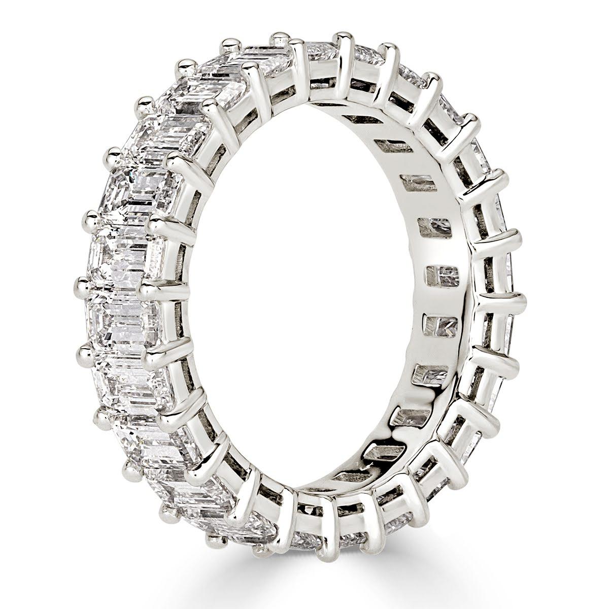 Custom created in 18k white gold, this captivating emerald cut diamond eternity band features 4.87ct of perfectly matched emerald cut diamonds graded at E-F in color, VVS2-VS1 in clarity. All eternity bands are shown in a size 6.5. We custom craft