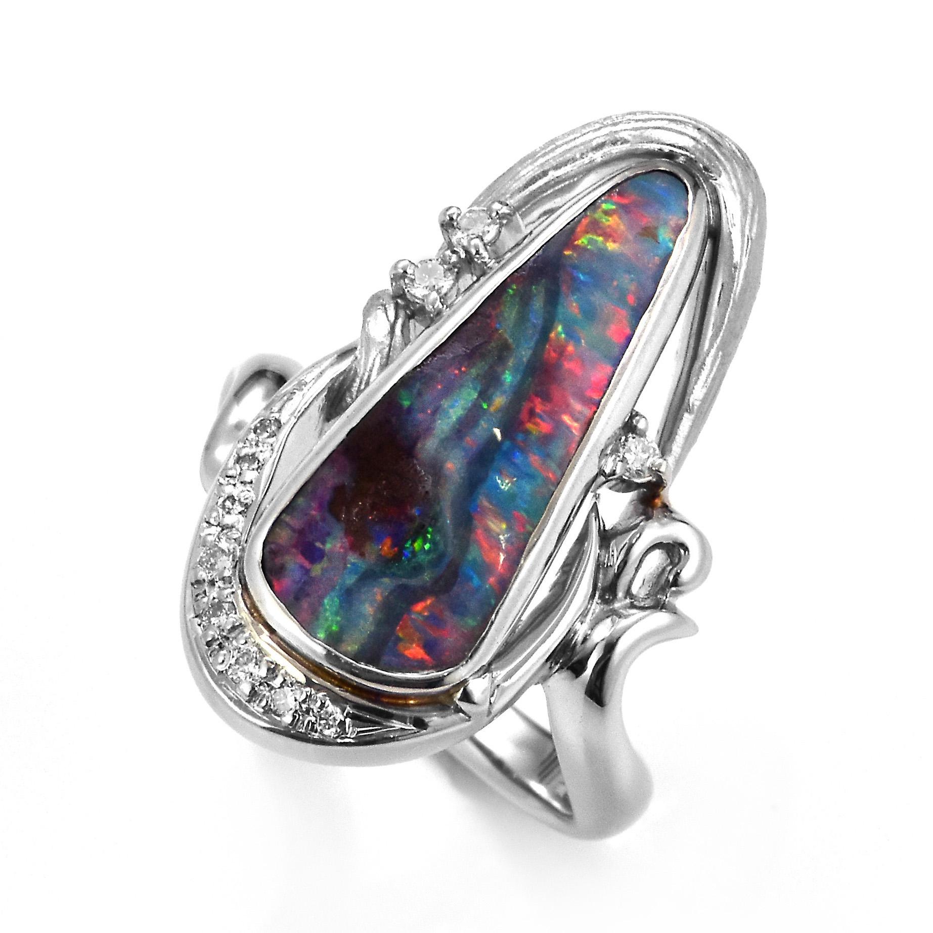 A beautiful ring featuring a 4.87 Carat, Natural, Australian Boulder Opal and 0.13 Carats of Diamond Accents set in Platinum. The Opal displays very good play of color! Opals are known for exhibiting flashes of rainbow colors known as 