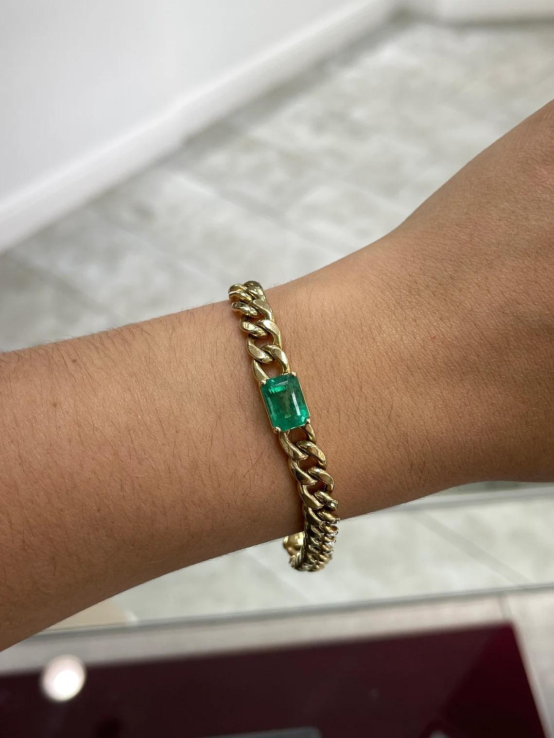 Take a peek at this stunning solitaire, natural emerald bracelet. The featured gemstone is a stunning 4.87-carat, natural Zambian emerald displaying great eye clarity and luster. Set in a 14K yellow gold, four-prong setting attached to a solid Cuban