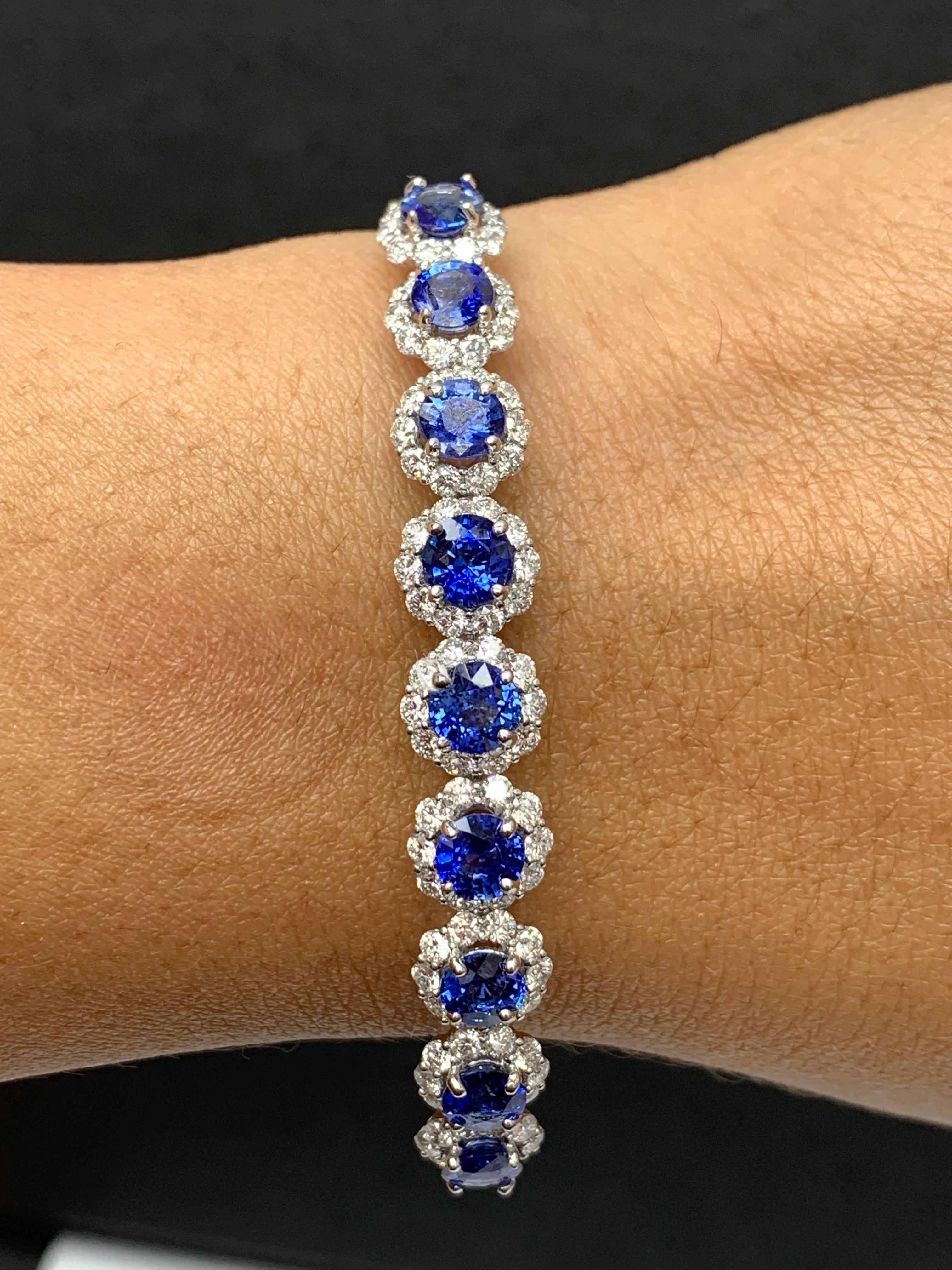 Sparkle in the spotlight with this brilliant cut ruby and diamond bangle bracelet. Features 9 brilliant-cut round blue sapphires weighing 4.88 carats and surrounding the blue sapphires are 90 diamonds weighing 2.45 carats elegantly set in an 18k