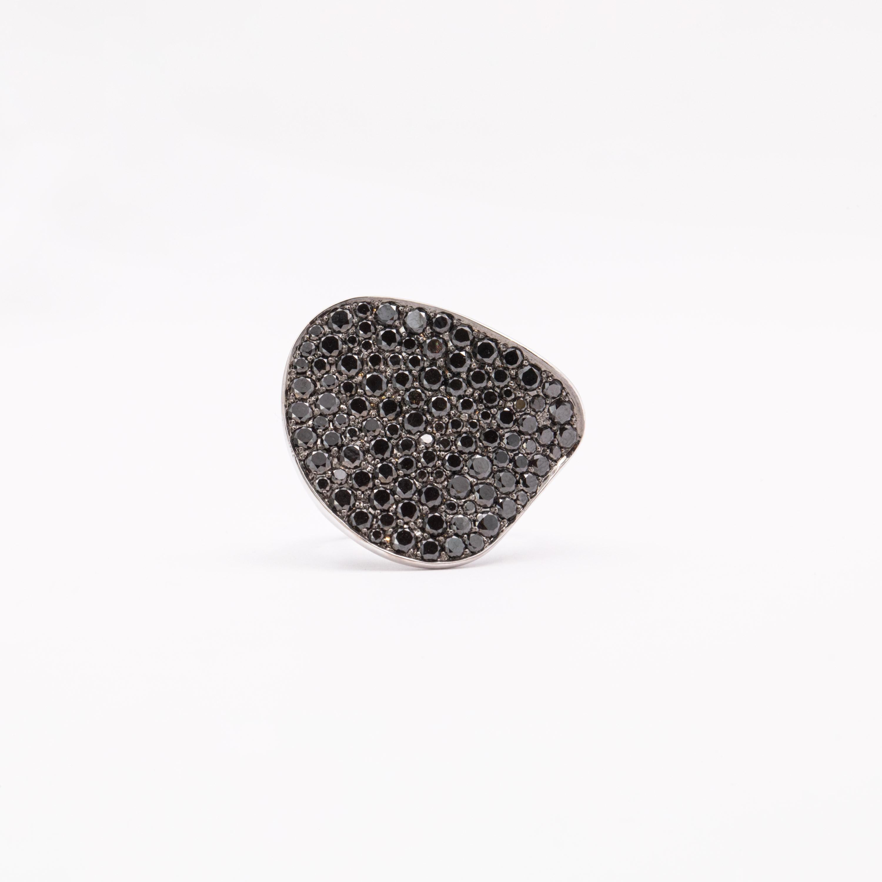 The elegantly curved surface of this remarkable piece is encrusted with a number of 110 black diamonds weighing 4.88 carats. Resembling a leaf bending in the wind, this unique design confers this ring an insouciant appeal, with the undulation