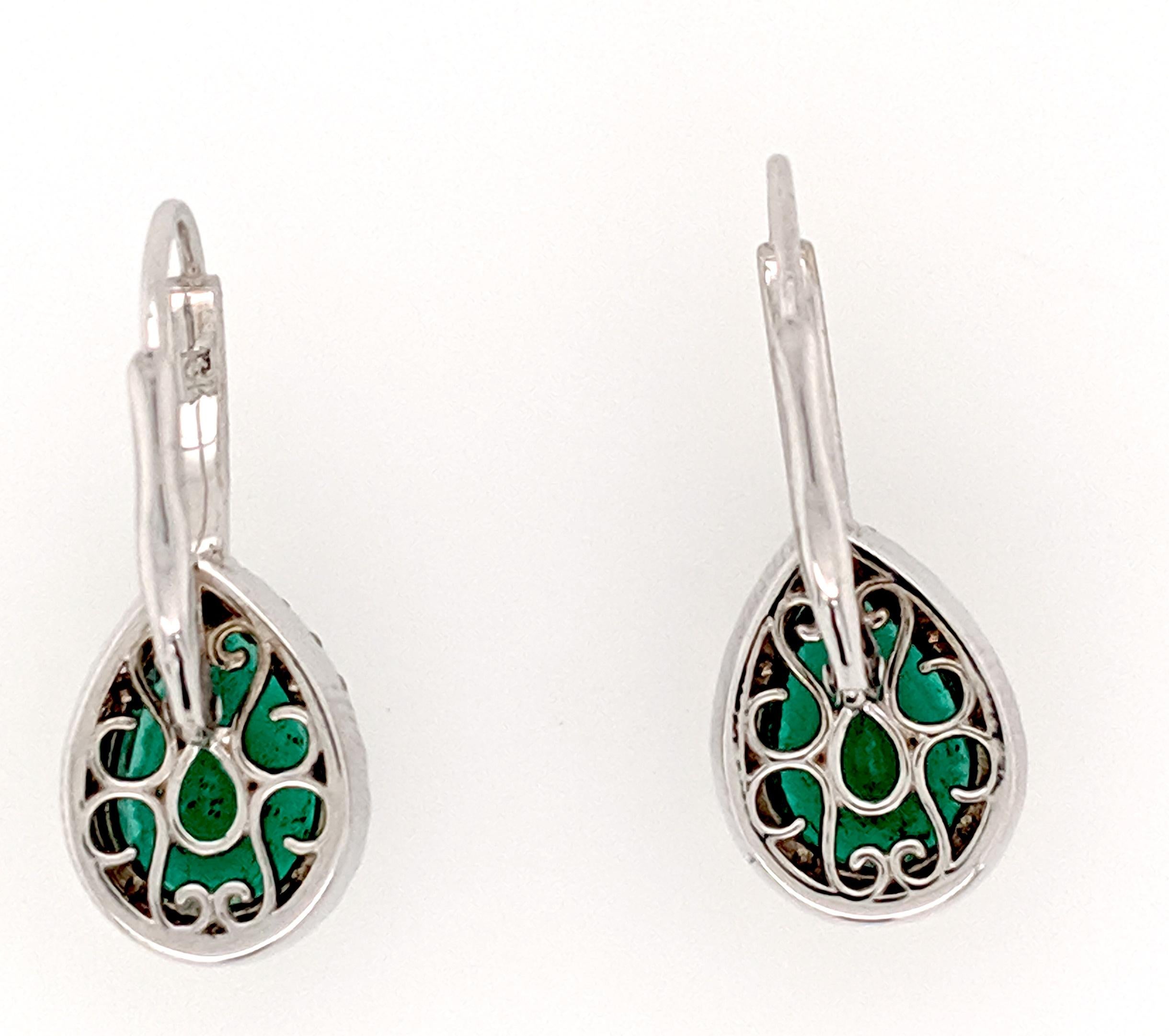These emerald and diamond earrings are crafted in 18k white gold and feature (2) Pear shaped emeralds that are perfectly matched from the Sandawana mines in Africa and weigh approximately 4.88cttw with Gem color and clarity. There are (54) round