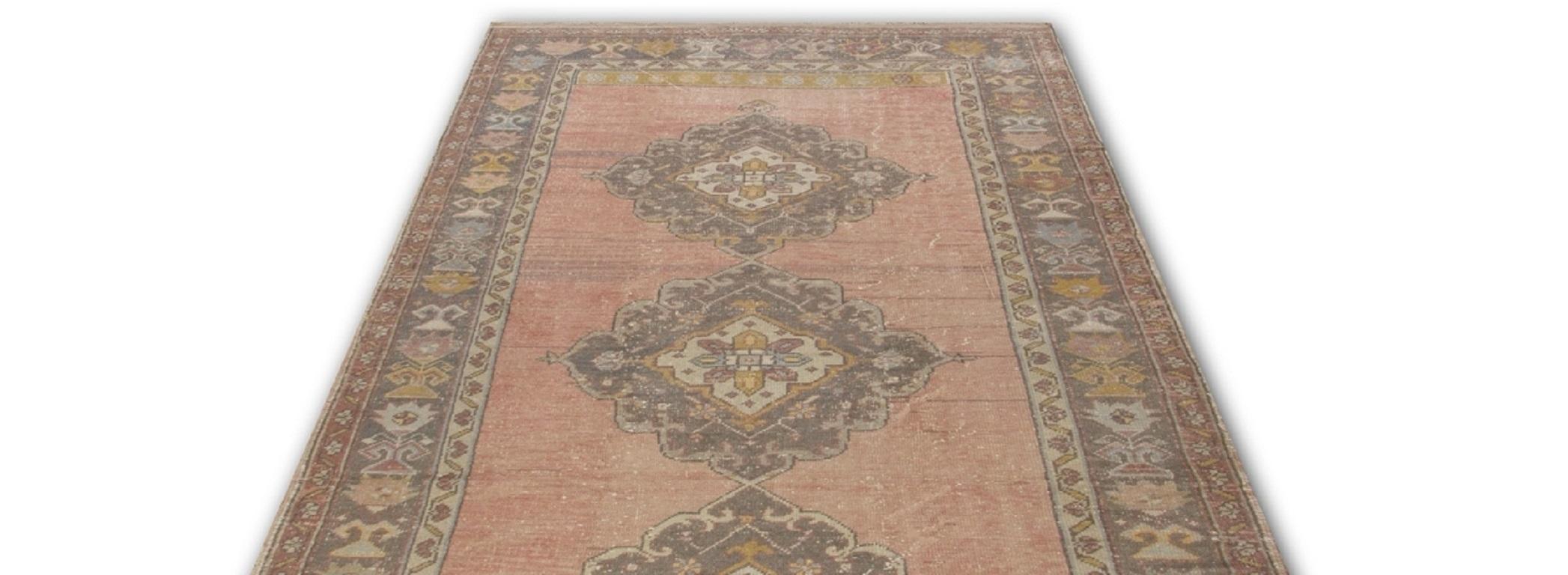 A finely hand-knotted vintage Turkish runner rug from the 1960s with even low wool pile on cotton foundation. It features linked medallions running across its length against a plain field and a large three-layered larger border decorated with