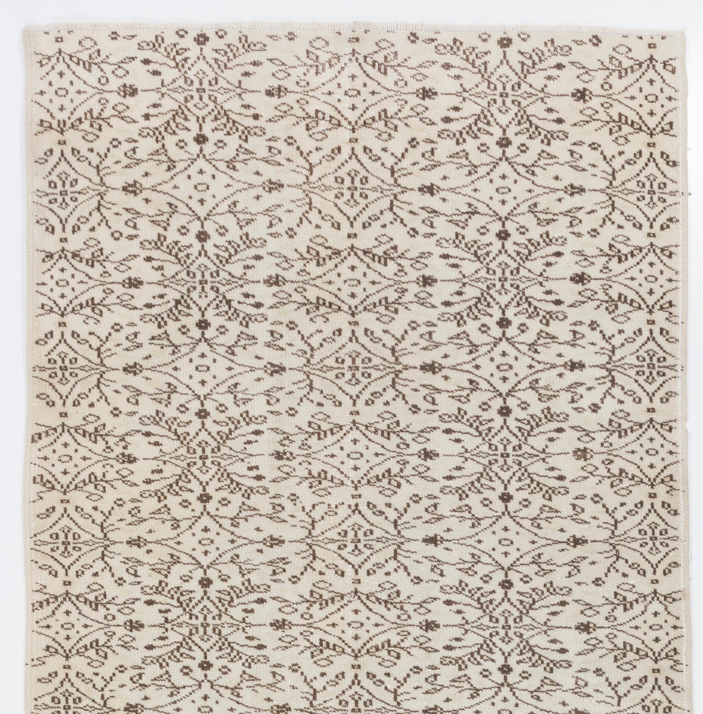 A vintage hand-knotted runner rug from central Turkey with an all-over design of dainty leafy vines around elongated diamond-shaped lattices in brown against an ivory background. It is finely hand-knotted with even medium wool pile on cotton
