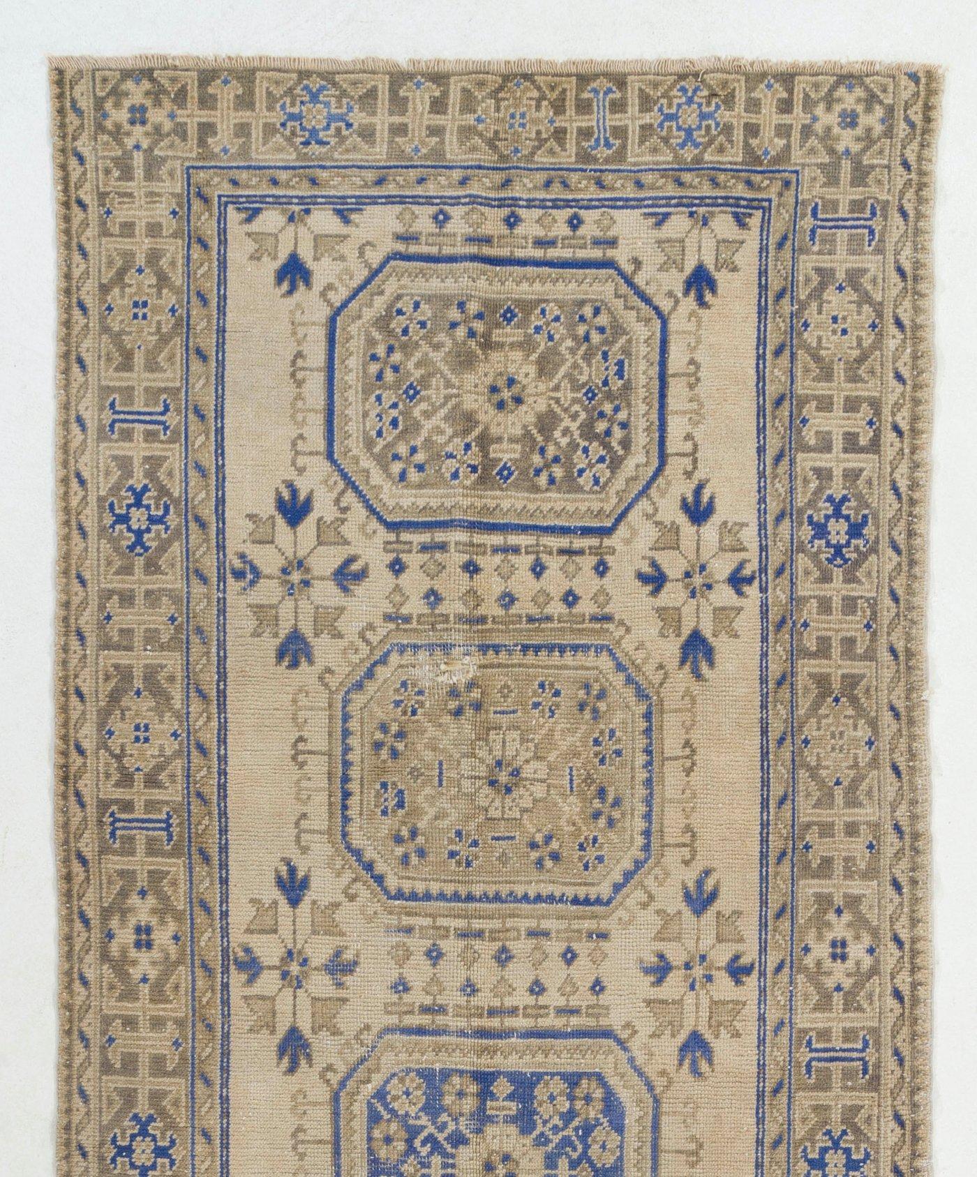 Alfombra de pasillo turca vintage, anudada a mano con pelo bajo de lana sobre base de algodón. Presenta medallones geométricos decorados con motivos florales. Está en buen estado, lavada profesionalmente y es resistente. Medidas: 4,8 x 12 pies.