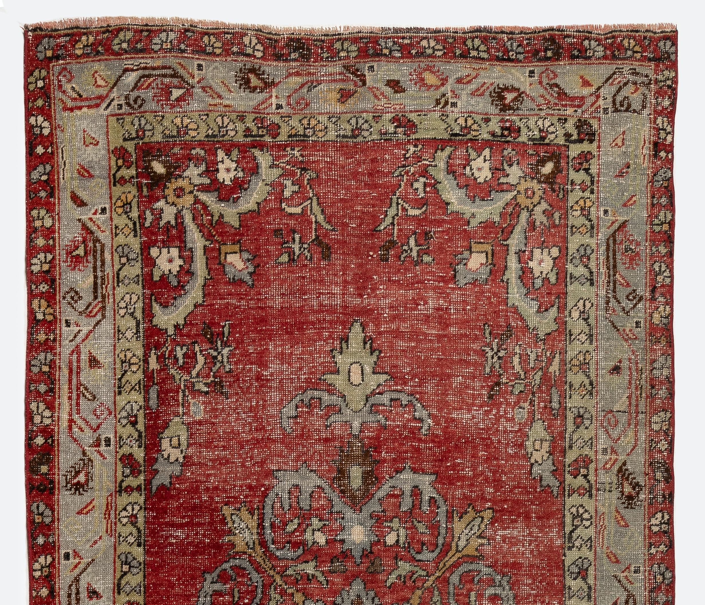 A vintage hand-knotted runner rug from Turkey with distressed low wool pile on cotton foundation that features two linked medallions with arabesque outlines in light blue against a red field and a main border in light blue. 

The rug is in good