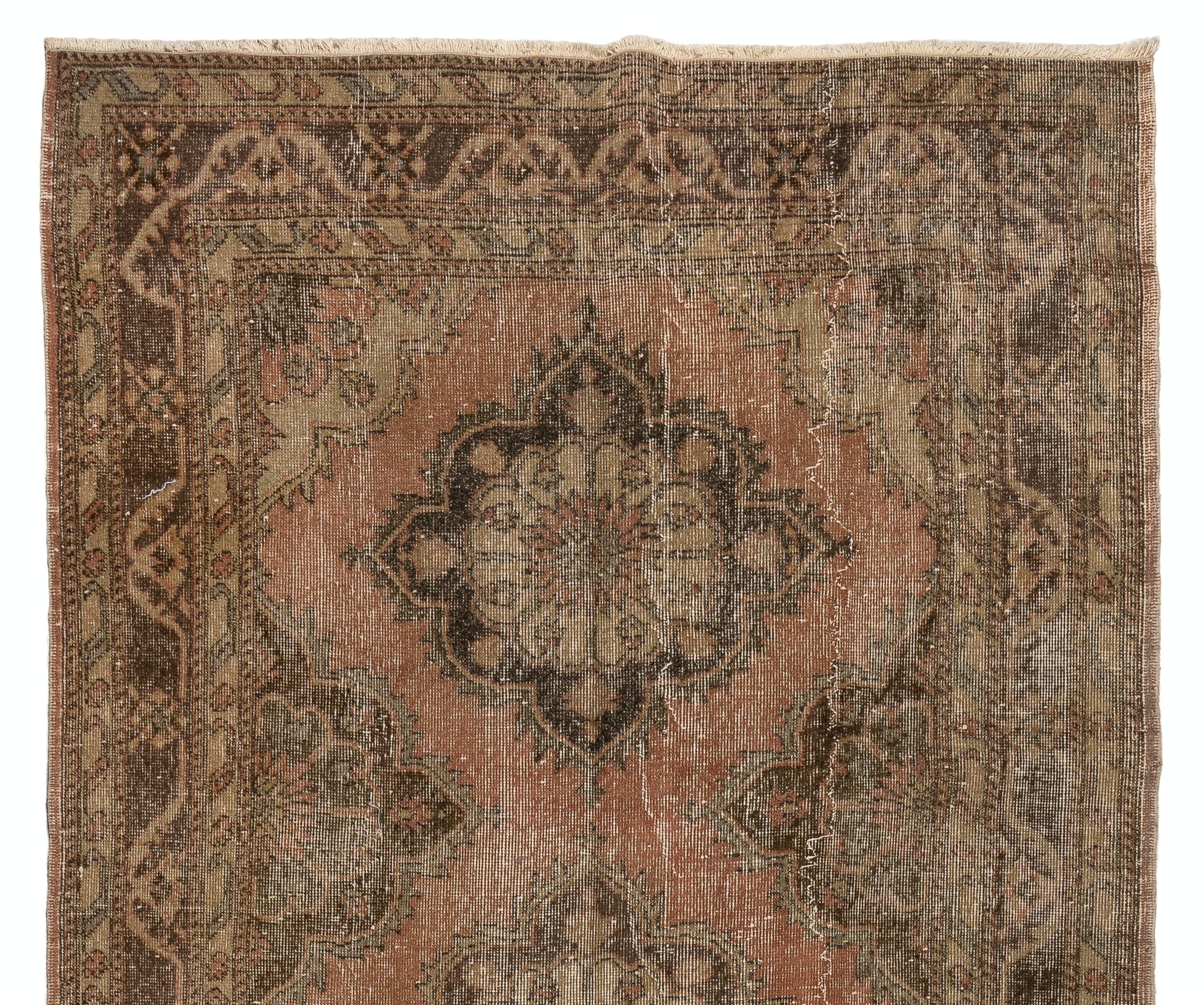 A  vintage Turkish runner rug for hallway decor in brown, fawn and faded dark coral pink. It was hand-knotted in the 1960s with low wool on cotton foundation and features a multiple medallions design. It is in very good condition,