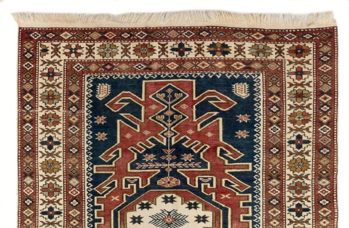 This gorgeous vintage hand-knotted Turkish area rug. It is made of soft, lustrous sheep's wool on wool foundation, is in very good condition, sturdy and clean as a brand new rug. It features a well-drawn geometric design with a medallion at its