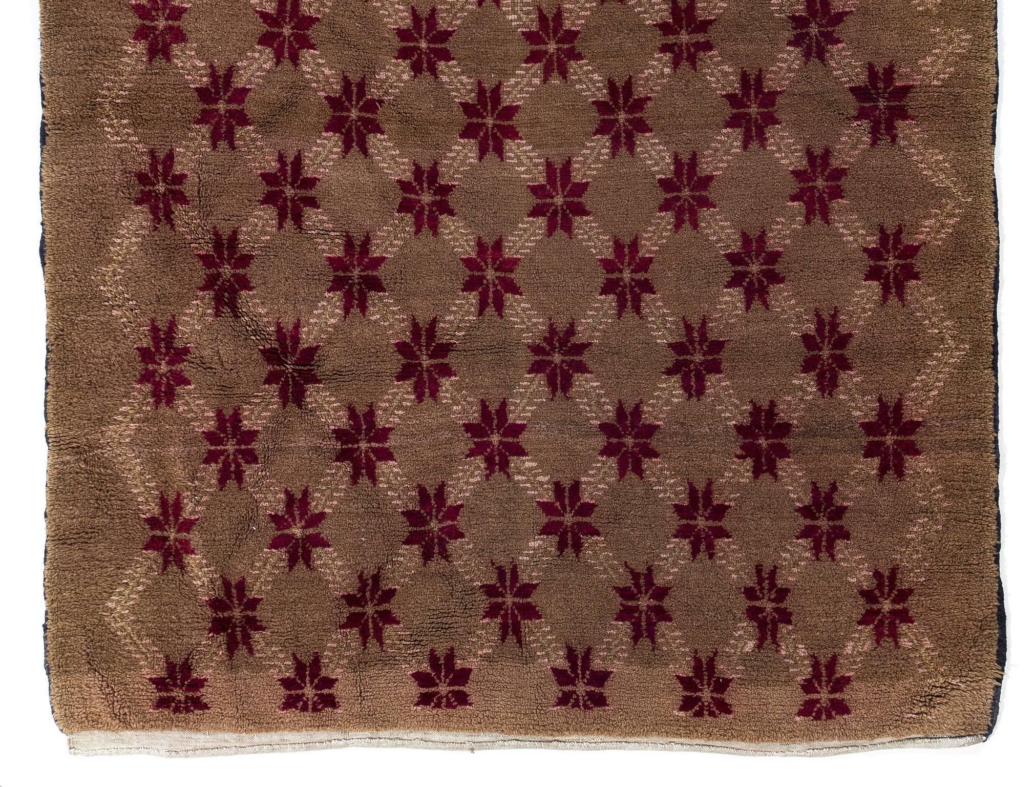 This unique vintage Central Anatolian rug is quite striking with its overall floral lattice design and its color story. The contrast between the latte background and the crimson red florals along with the ivory lattices made of dainty little leaves