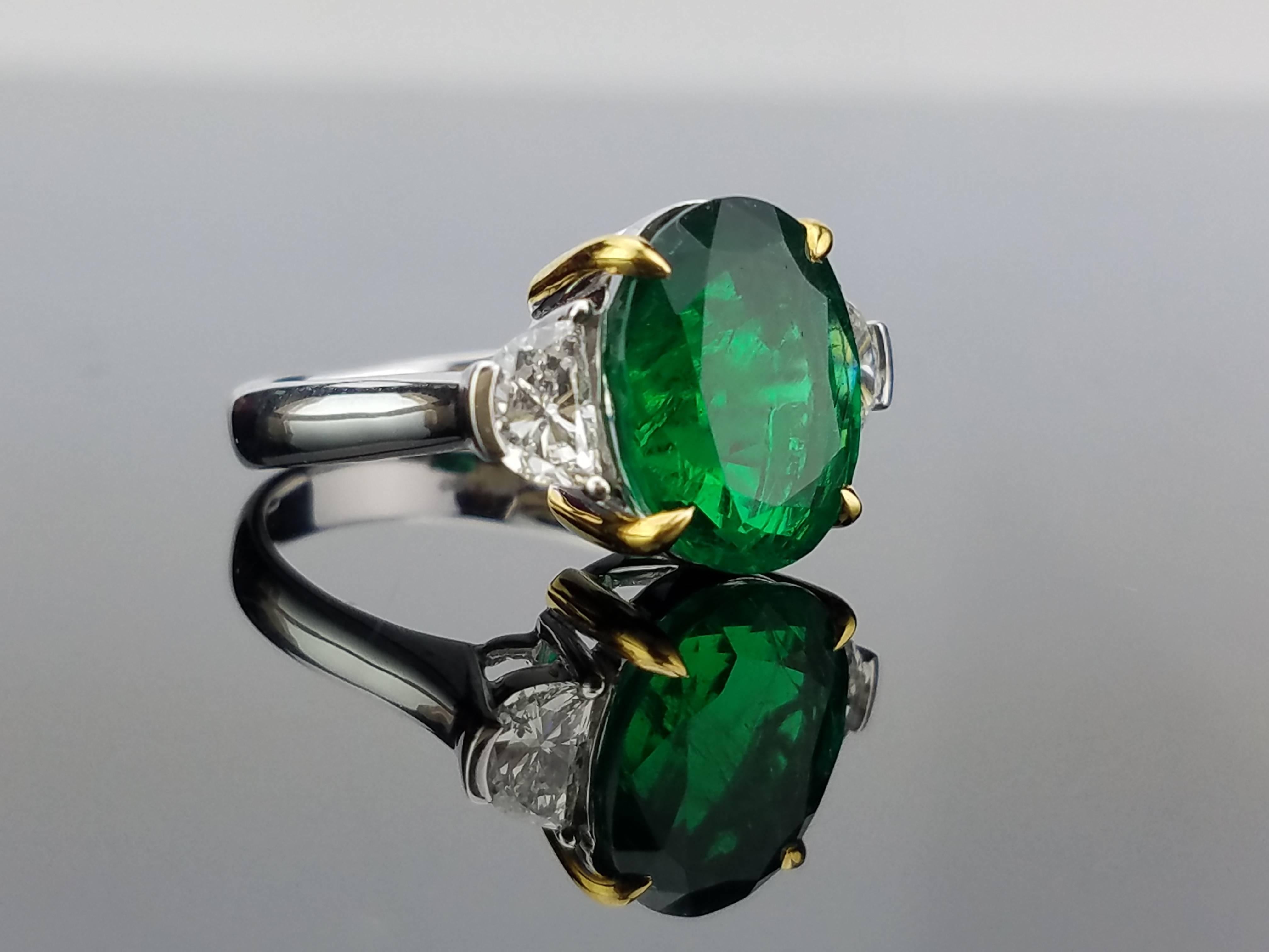An elegant three stone ring using a beautiful oval shaped emerald centre stone and 2 half-moon white Diamond, all set in 18K white gold. 

Stone Details: 
Stone: Emerald
Carat Weight: 4.90

Diamond Details: 
Total Carat Weight: 0.81 carat
Quality: