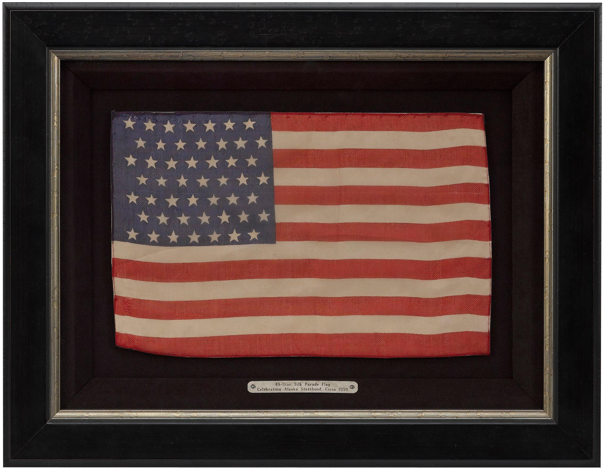Presented is a 49-star American flag, celebrating Alaska statehood. The flag is printed on silk and has seven rows of seven stars in a staggered row pattern printed on the bright blue canton.

Alaska’s long path to statehood started in 1867, when