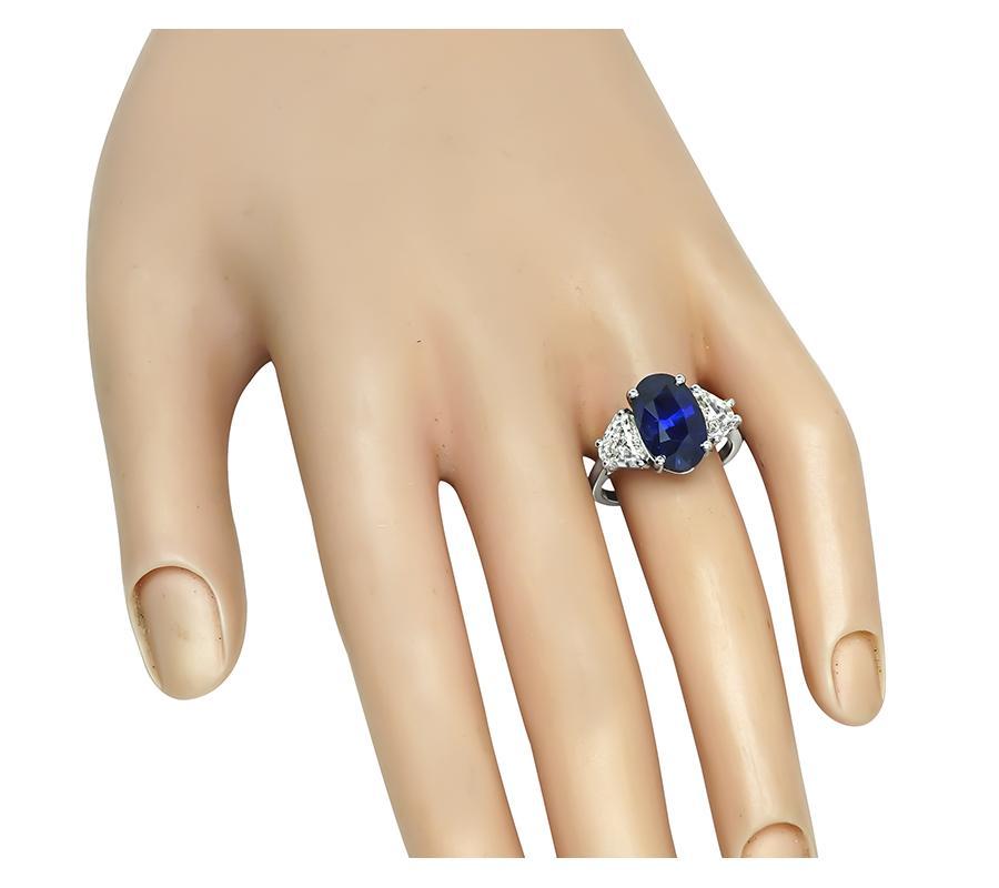 This is an amazing platinum engagement ring. The ring is centered with a lovely oval cut sapphire that weighs approximately 4.90ct. The center stone is accentuated by sparkling shield cut diamonds that weigh approximately 1.61ct. The color of these
