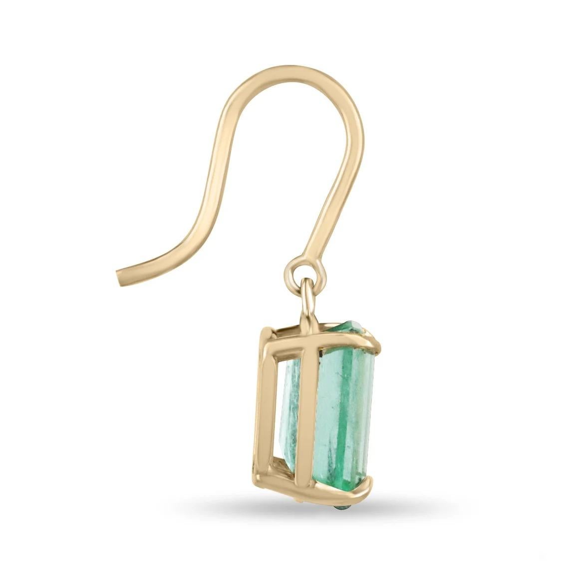 A simple pair of emerald cut-emerald lever back earrings made in 14K yellow gold. The chic pair of lever-back earrings feature green, natural Emeralds. The emeralds have beautiful eye clarity, displaying minor flaws that are normal in all