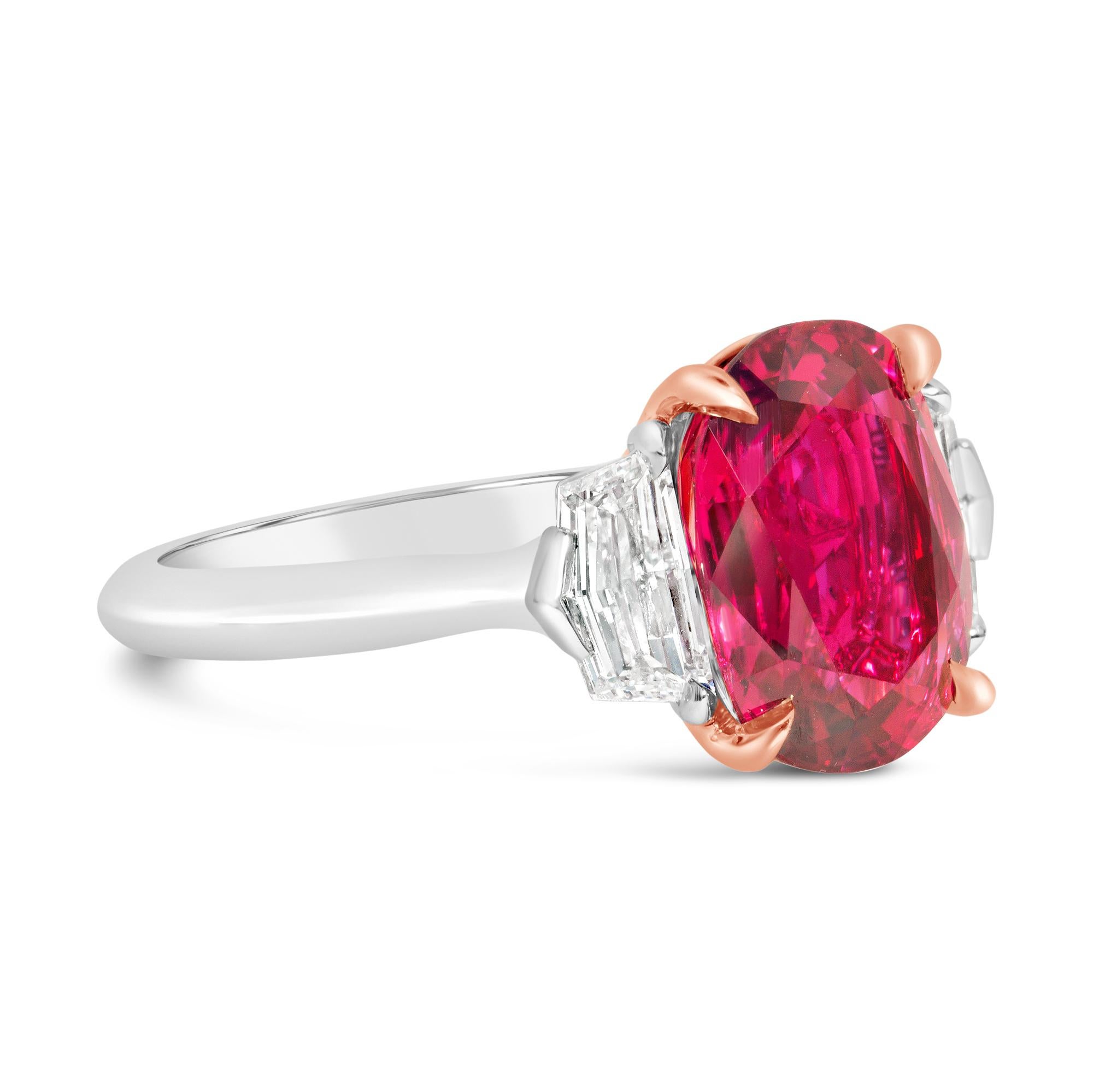 A gorgeous engagement ring, featuring a 4.91 carats oval cut ruby, set on a classic four prong basket made of 14K rose gold. Flanked by epaulette cut diamonds weighing 0.81 carat total. Elegantly made with a platinum mounting. Size 6.5 US, resizable