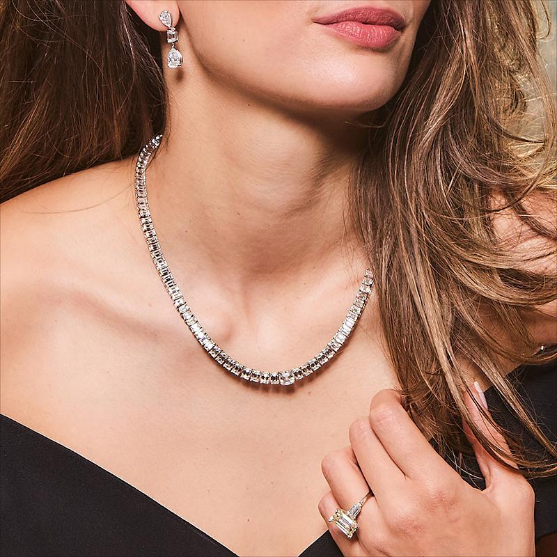 Offrez-vous le luxe avec notre collier Riviera à diamants taillés en émeraude. Ce chef-d'œuvre de 19 pouces comporte 128 diamants taille émeraude méticuleusement sertis, créant ainsi un éblouissant spectacle de brillance. La pièce maîtresse est un