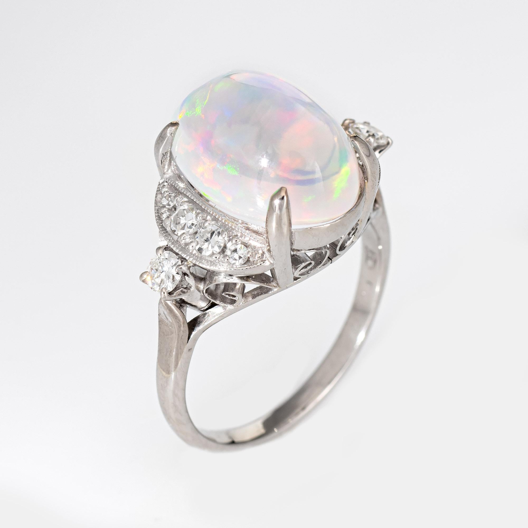 Stylish natural jelly opal & diamond cocktail ring crafted in 900 platinum. 

Cabochon cut natural jelly opal, 4.92 carats (11.40 x 9mm x 9.3mm). The opal  is in excellent condition and free of cracks or chips. The opal exhibits a strong play of