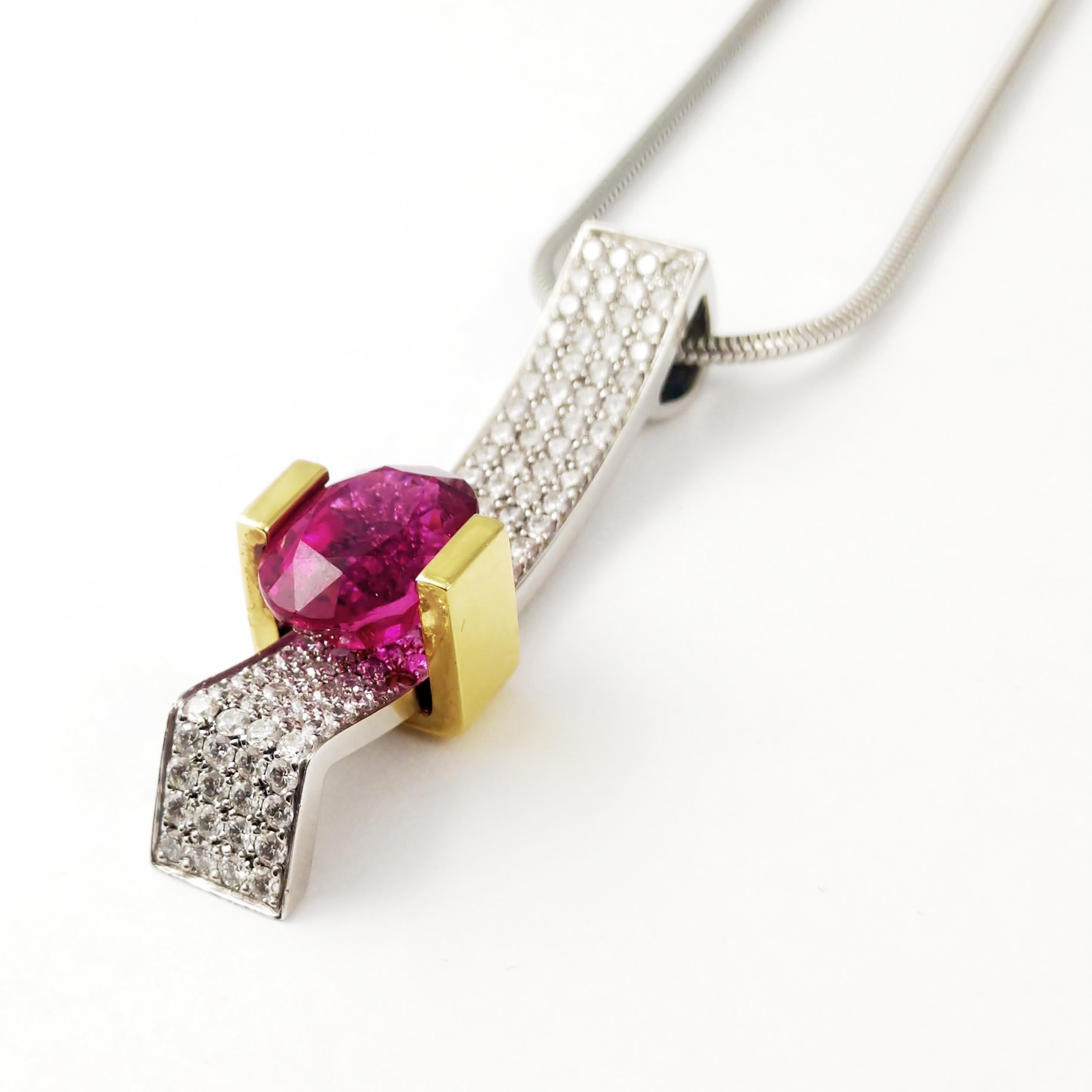 This distinctive 18KT yellow and white gold drop pendant is featuring a rich raspberry colored 4.92ct oval Rubellite that is channel set.  This unique one-of-a-kind necklace features 1.68ct. total of round brilliant diamonds hand-set French pave