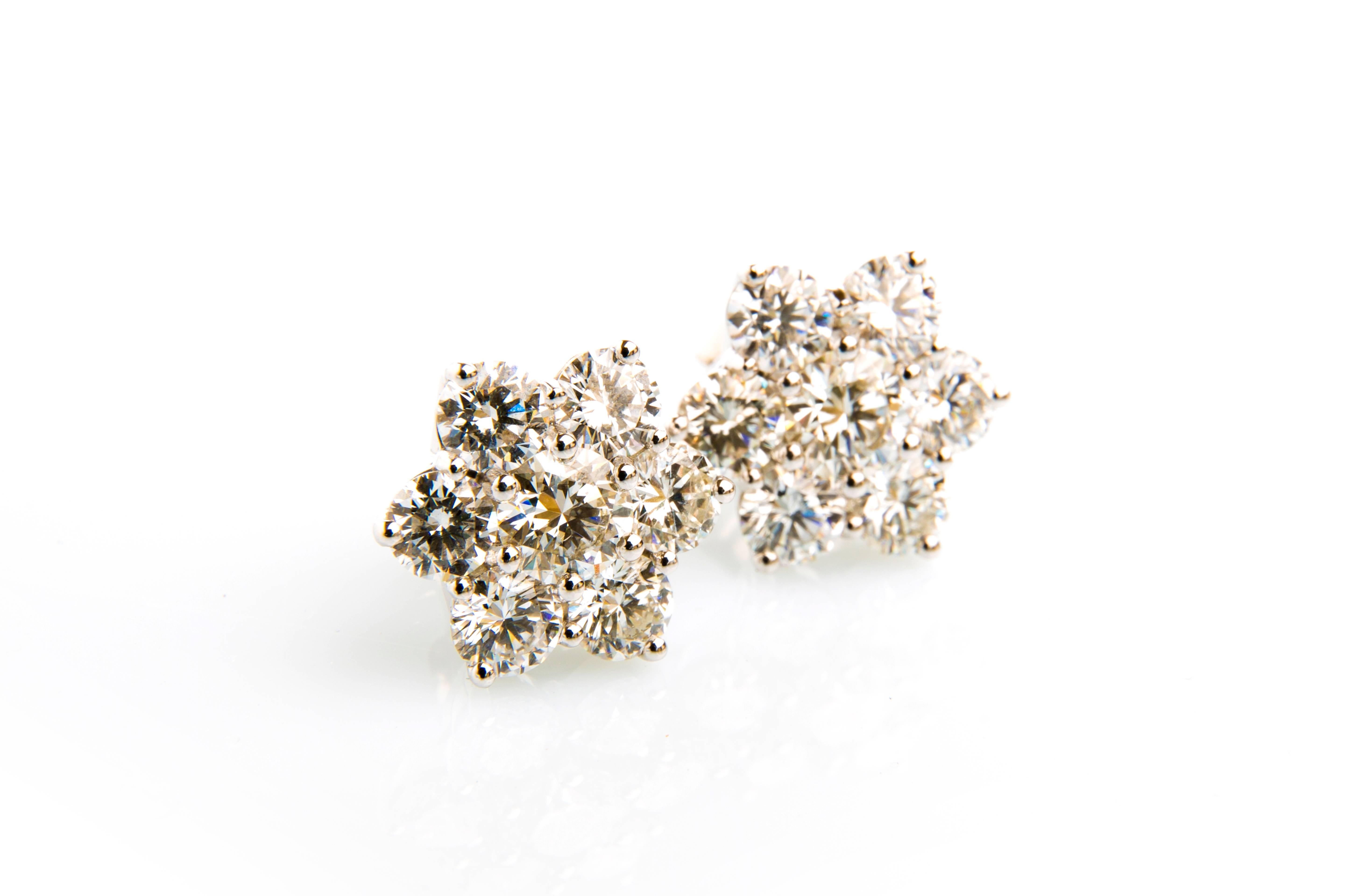 snowflake shaped pair of round diamond cluster earrings 
two round diamonds 1.18 cts & twelve round diamonds 3.75 cts 
G/ VS1/ 3ex
18k white gold