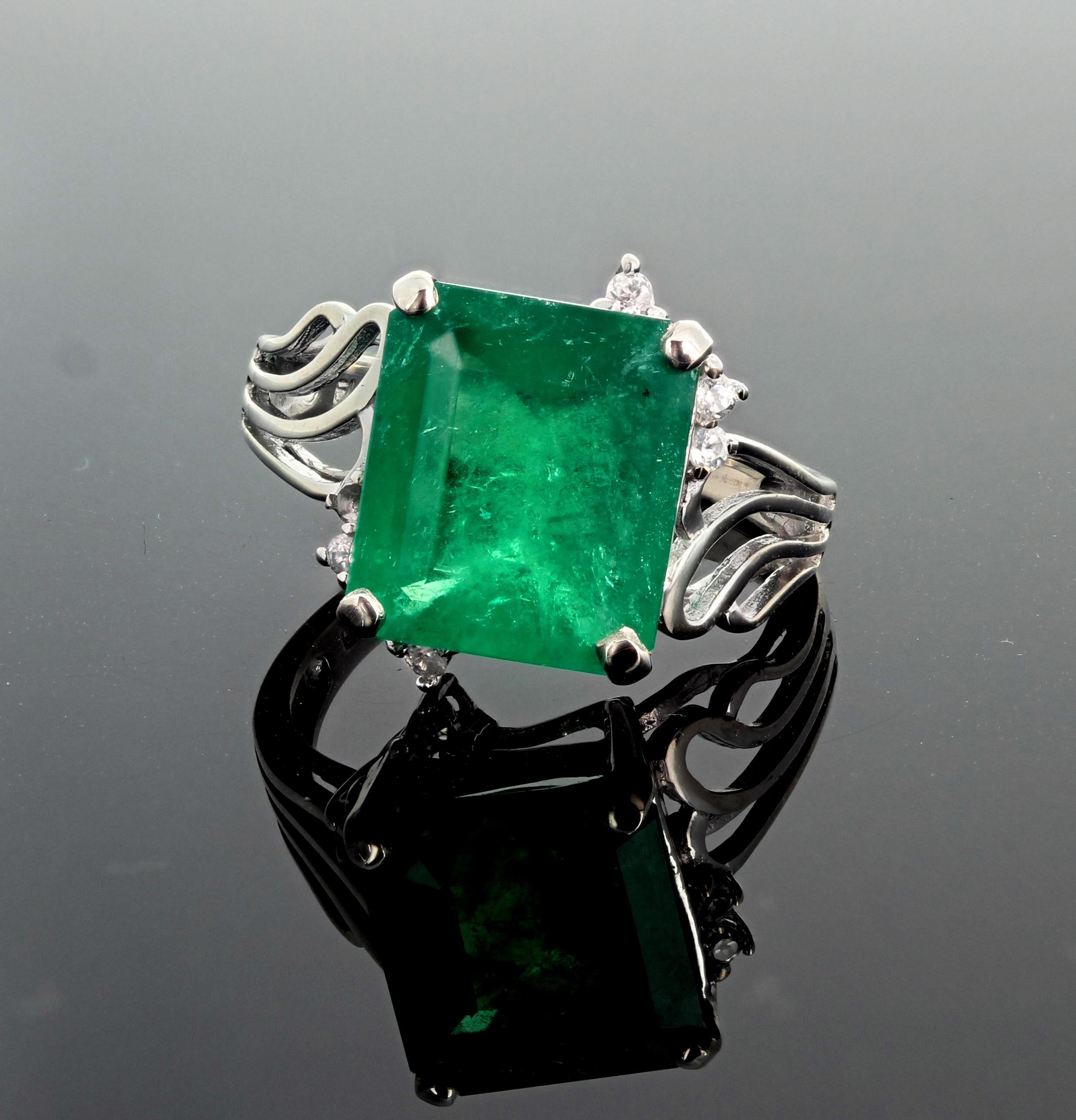 Unique 4.93 Carat green Emerald (12 mm x 10 mm) accented with sparkling white diamonds set in a handmade white gold ring size 7 (sizable).  This is a natural Brazilian Emerald.  More from this seller by putting gemjunky into 1stdibs search bar.