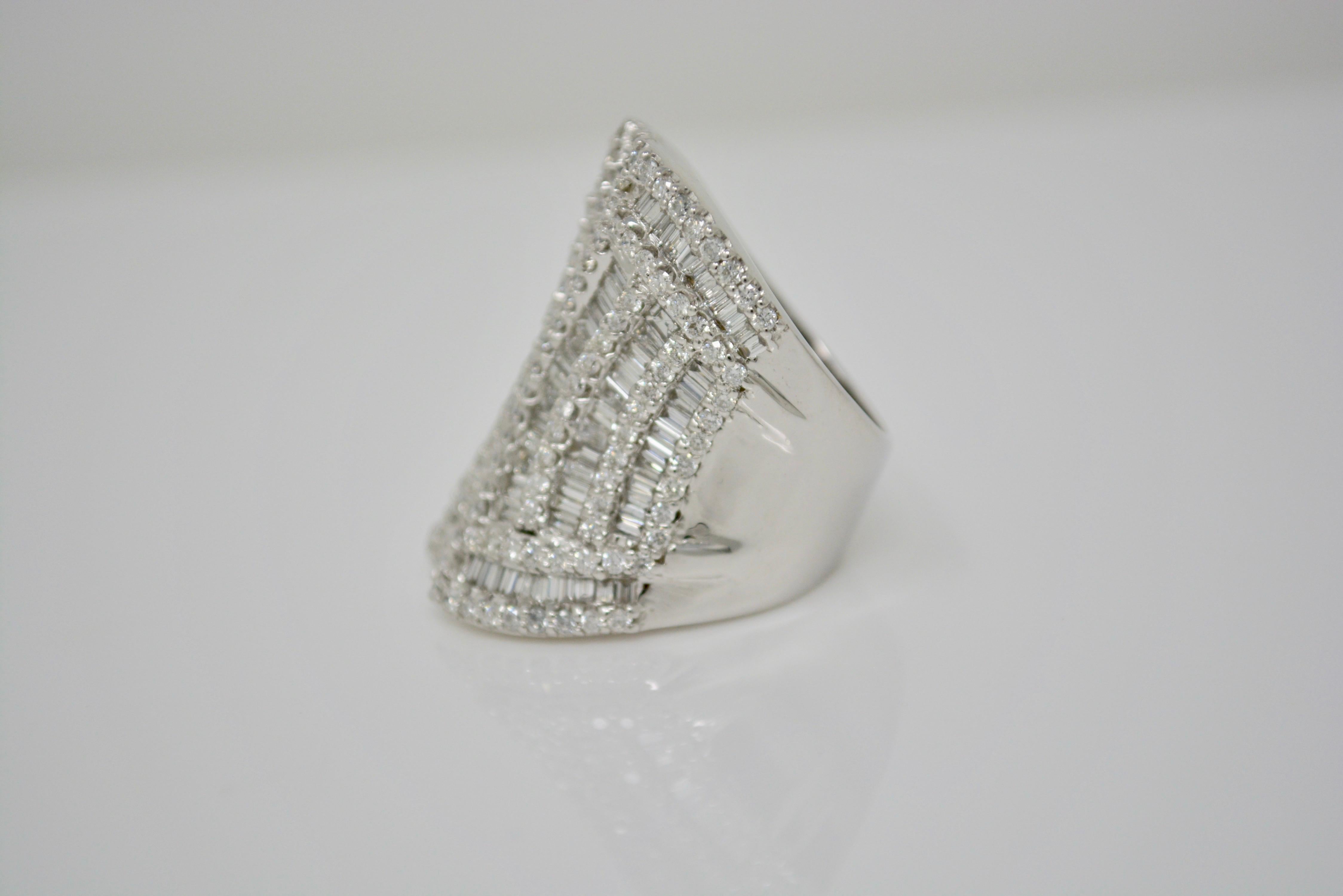 Big , bold and dramatic white diamond cocktail ring ! This spectacular handcrafted ring in 18K white gold features a total of 4.93 carat white round brilliant and baguette diamonds with G-H color and VS clarity . The ring size is 6 1/2. 
Gold weight