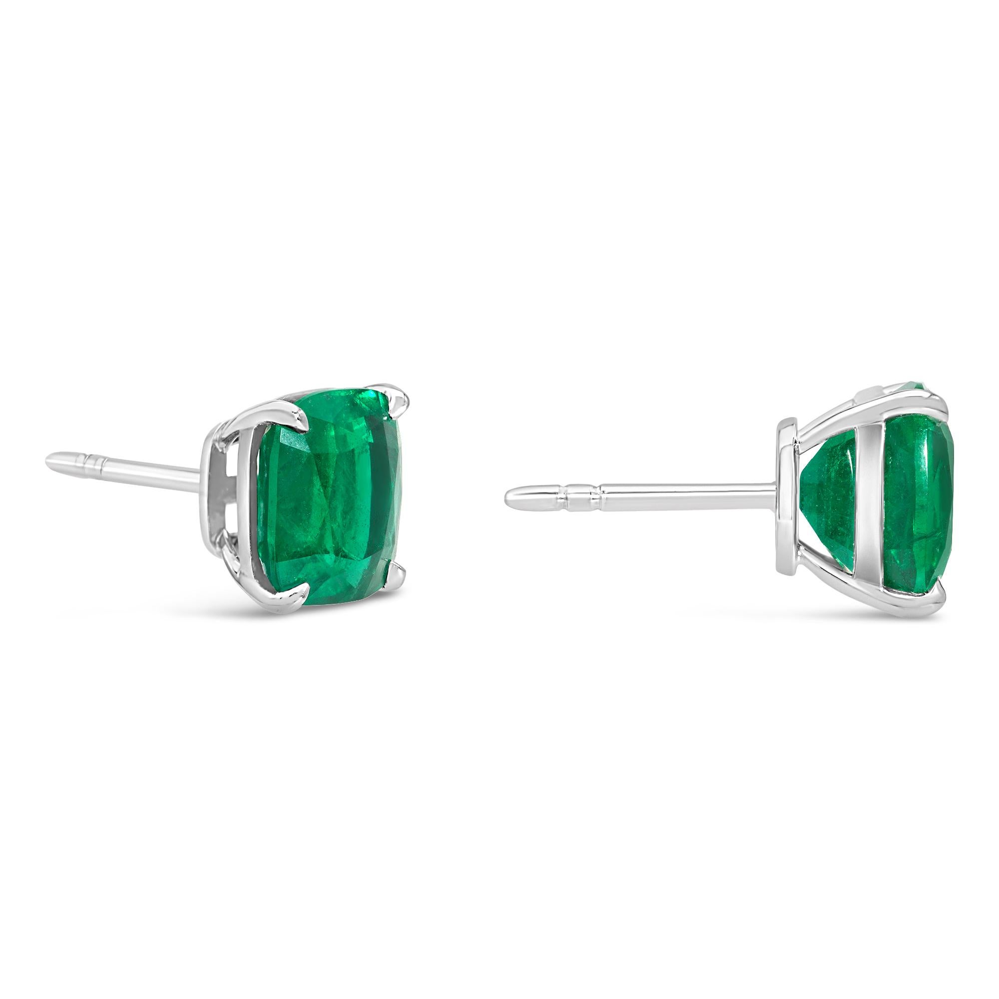 Une paire de boucles d'oreilles classiques, mettant en valeur des émeraudes vertes taillées en coussin pesant 4,93 carats au total. Serti sur une simple monture à quatre griffes en or blanc 18 carats. Parfait pour la vie de tous les jours. 

Roman