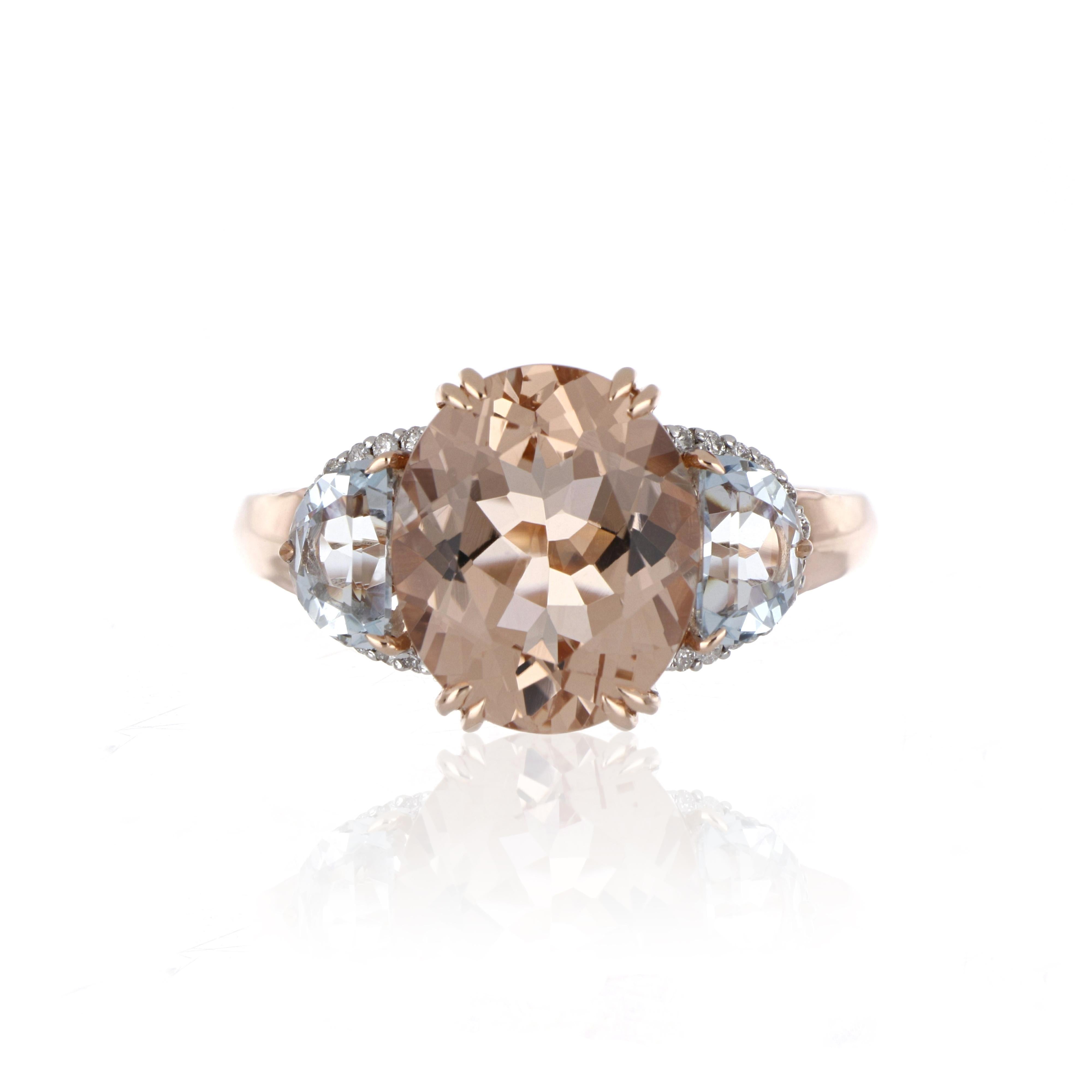 Elegant and exquisitely detailed three stone Cocktail 14K Ring, centre set with 3.98 Ct Oval Morganite and 0.95 Ct Half Moon Cut Aquamarine, surrounded by Diamonds, weighing approx. 0.11 cts. total carat weight. Beautifully Hand crafted in 14 Karat