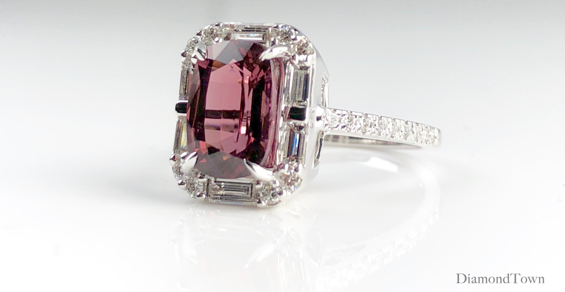 This beautiful ring features a 4.95 carat cushion cut Raspberry Garnet center, surrounded by a halo of baguette  and round diamonds. Additional round diamonds trace down the side shank, bringing the total diamond weight to 1.19 carats.

Ring size