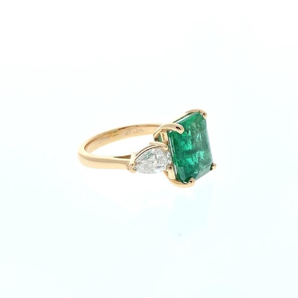 A square emerald as the main stone with a substantial weight of 4.95 carats. Additionally, there are two trilliant-cut diamonds serving as side stones, with a combined total carat weight of 0.57 carats.