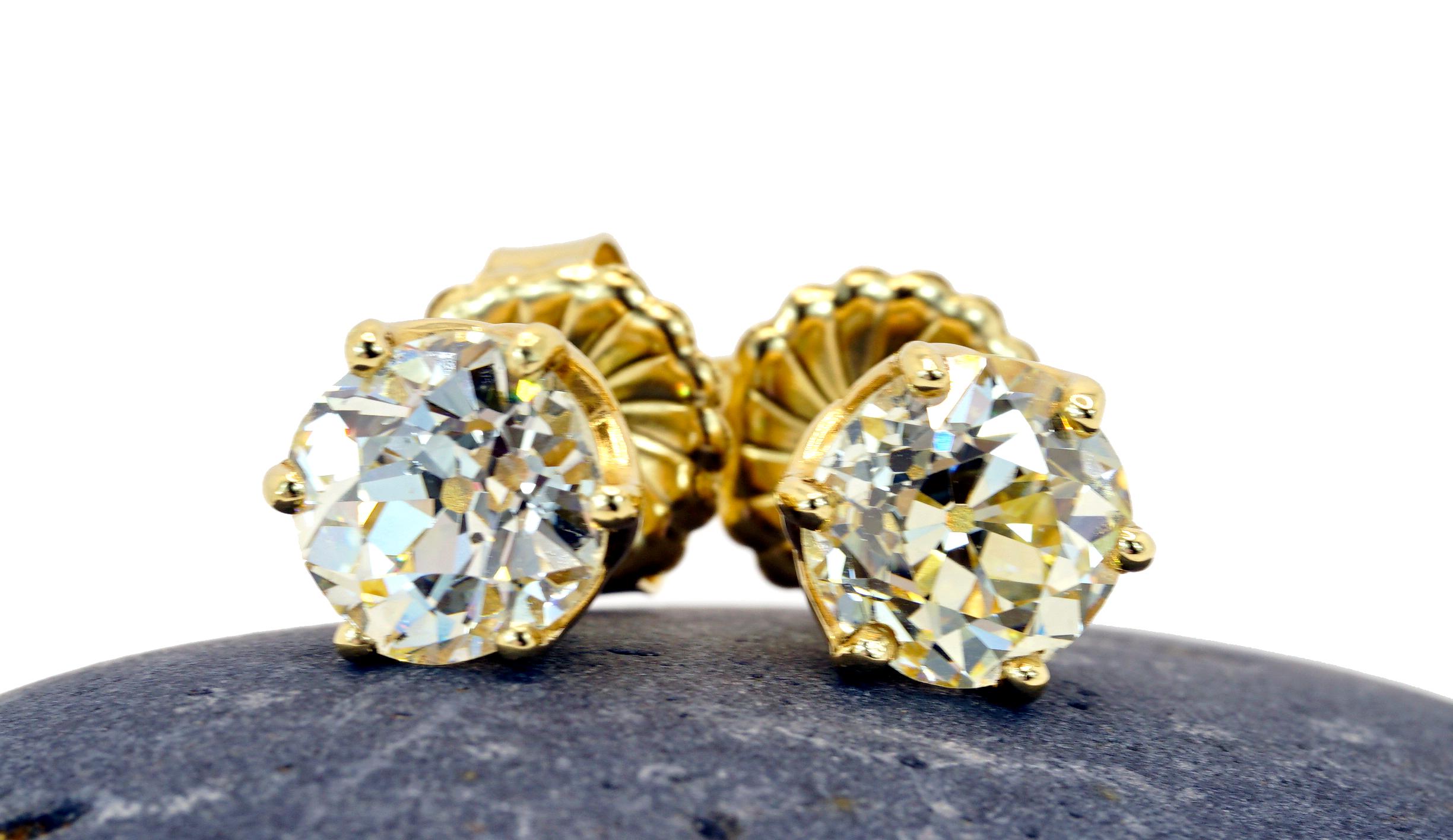 Two rare and natural Old European cut diamond stud earrings, weighing 4.95 Carats total , L-M in color SI1-SI2 in clarity. The old euro diamonds are set in a classic 14k yellow gold heavy six prongs with a filigree gallery and extra large backs.