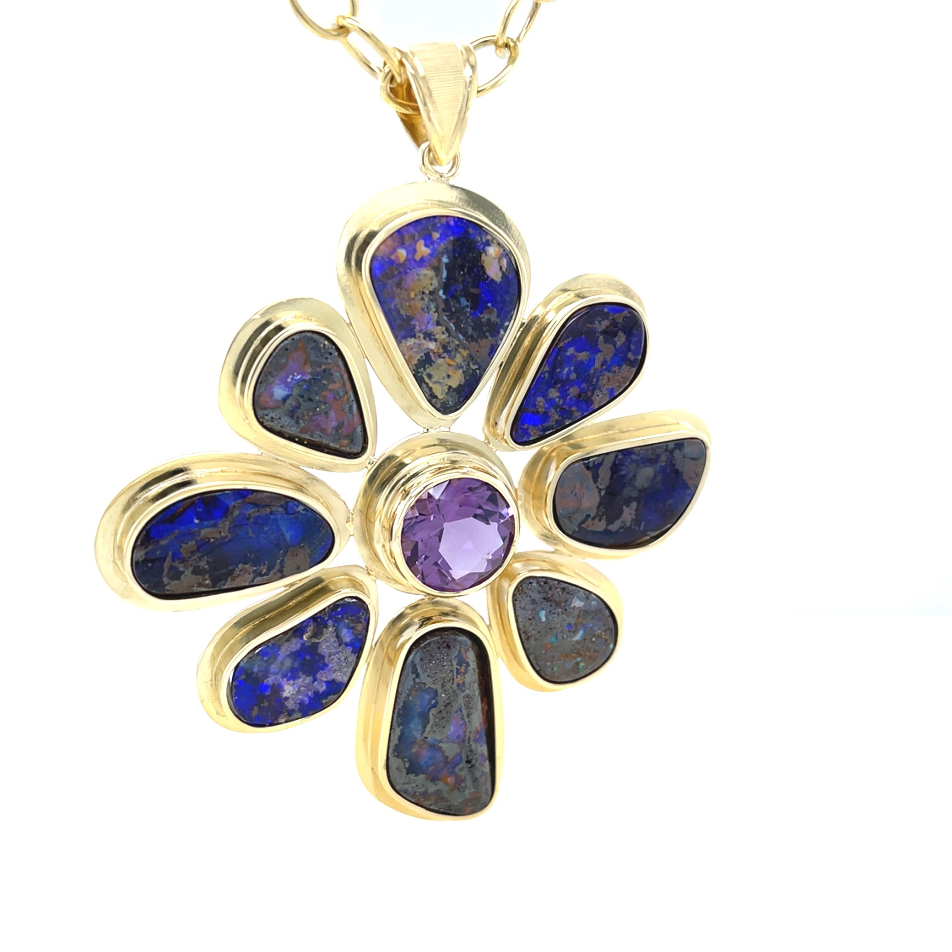 Ce magnifique pendentif fait à la main présente huit opales impressionnantes, magnifiquement disposées autour d'une améthyste ronde brillante de 5,48 carats ! Les opales ont des teintes bleu royal électrique et bleu violacé étonnantes qui ressortent