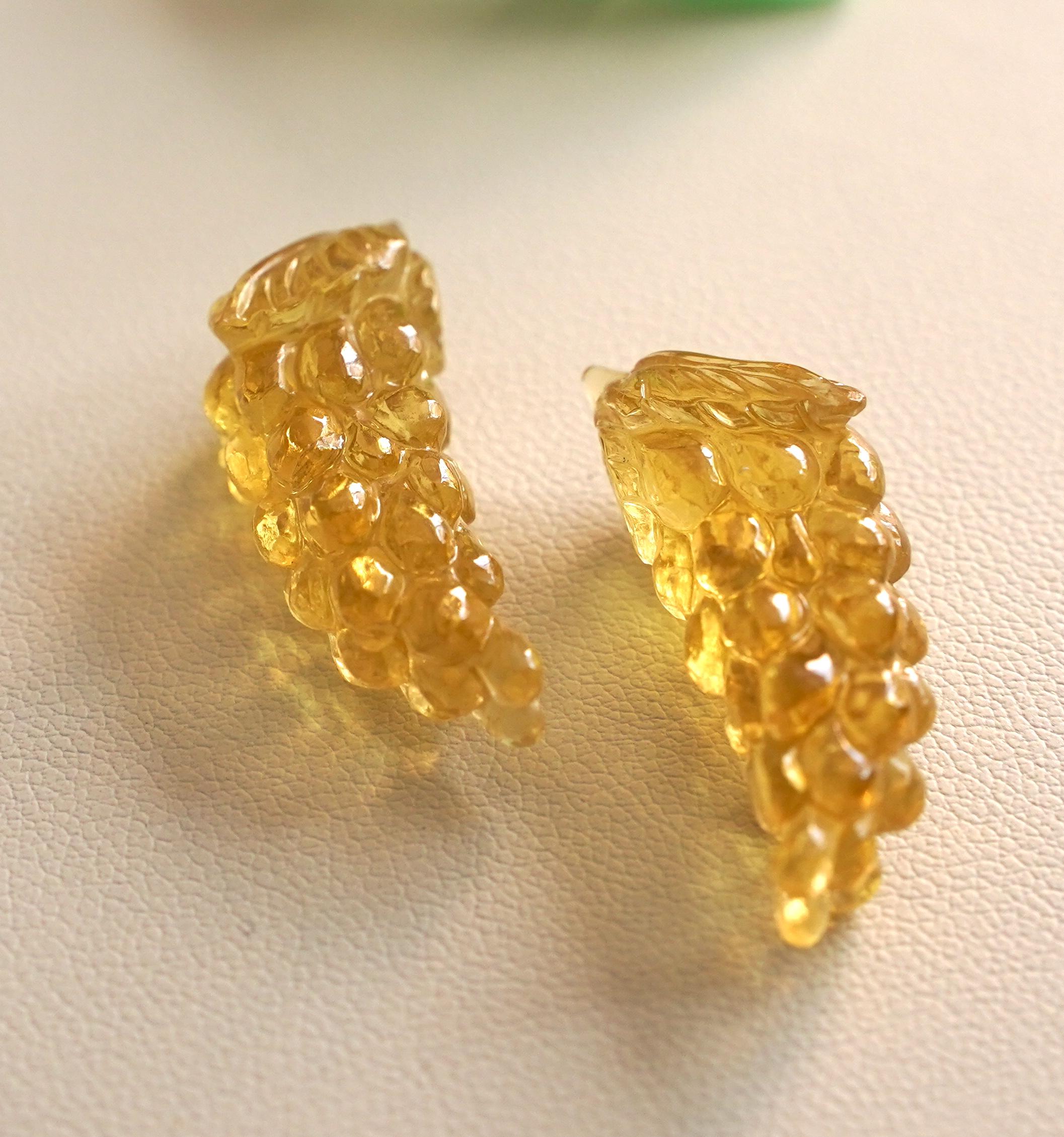 A carved pair of grapes in natural yellow apatite gemstone would make for a unique and eye-catching choice for earrings. Apatite is a gemstone that occurs in various colors, including yellow, and it is known for its vibrant hues and beautiful