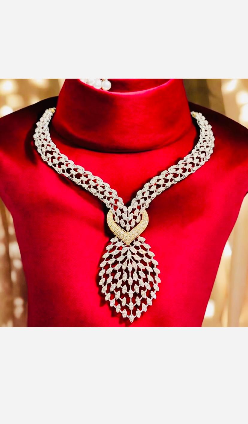 This beautiful necklace features a stunning design with 4.98 carats of round brilliant cut natural diamonds set in 14k white gold. The main stone is a white diamond with excellent cut grade and G color grade, accented by pavé setting style. The
