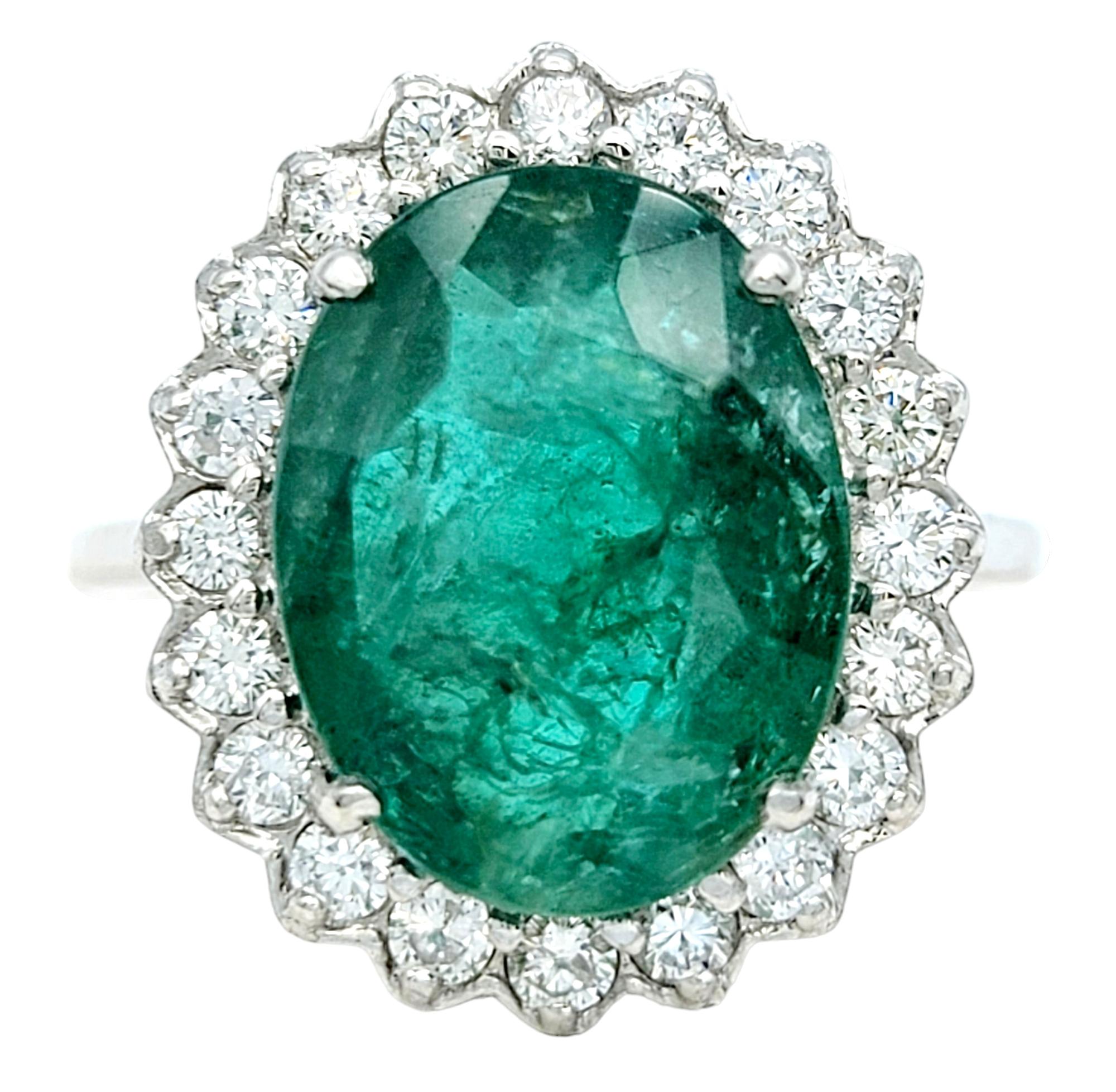 Ring size: 7.25

This exquisite ring is a dazzling testament to the beauty of natural gemstones. At its heart gleams a magnificent 4.98 carat oval-cut emerald, its bold green color exuding an aura of natural splendor. Encircling this lush gem is a