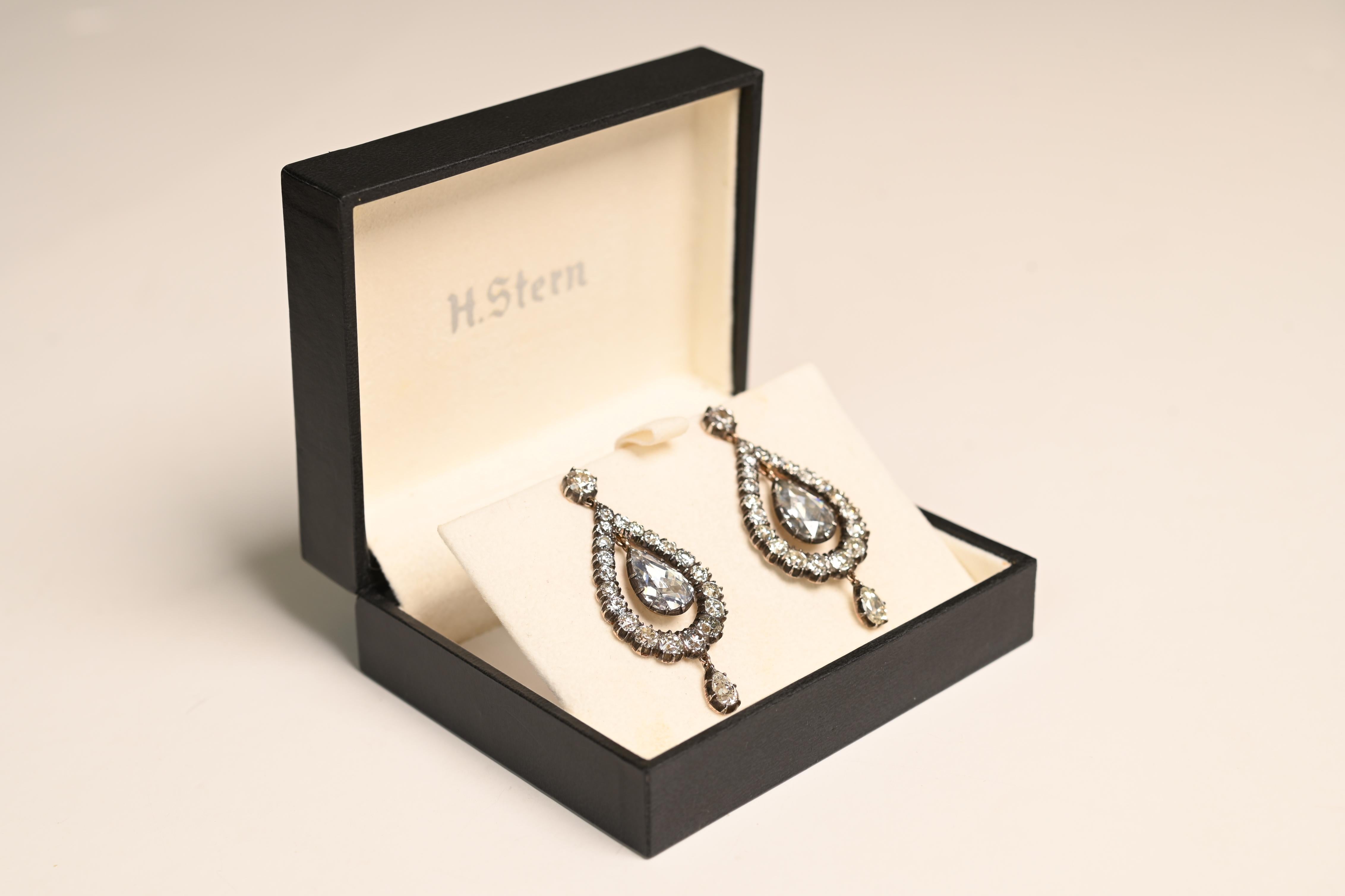 Presenting a stunning pair of Victorian-style earrings, expertly crafted with a silver-on-gold mounting. The focal point of these earrings is the rare and exquisite antique rose-cut diamonds, each cut over 100 years ago. The center stones, totaling